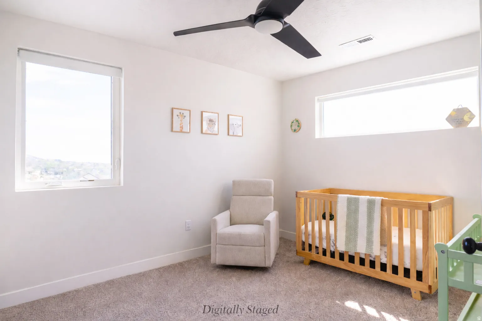 Carpeted bedroom with a nursery area and ceiling fan