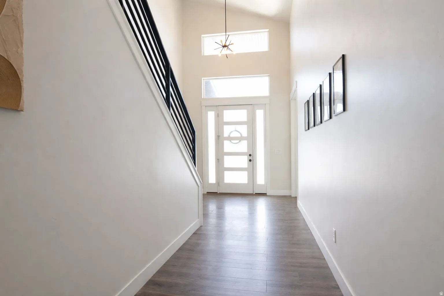 Foyer entrance featuring a high ceiling and dark wood-style flooring