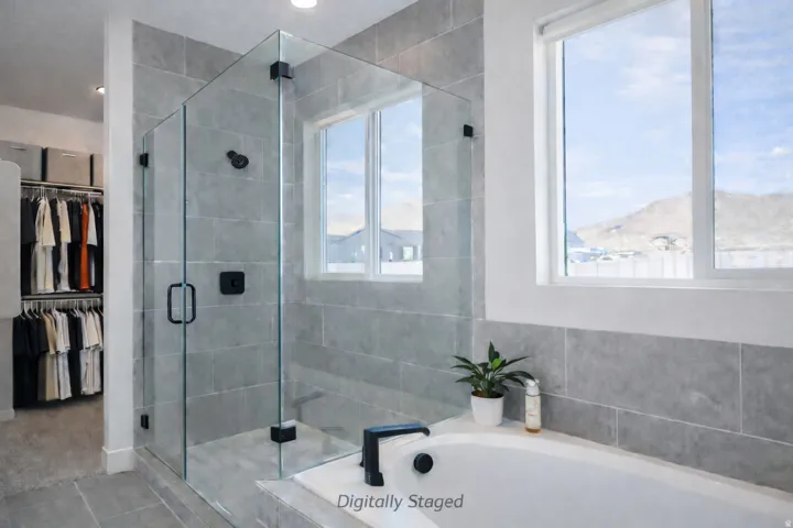 Bathroom with a walk in closet, a stall shower, and a bath