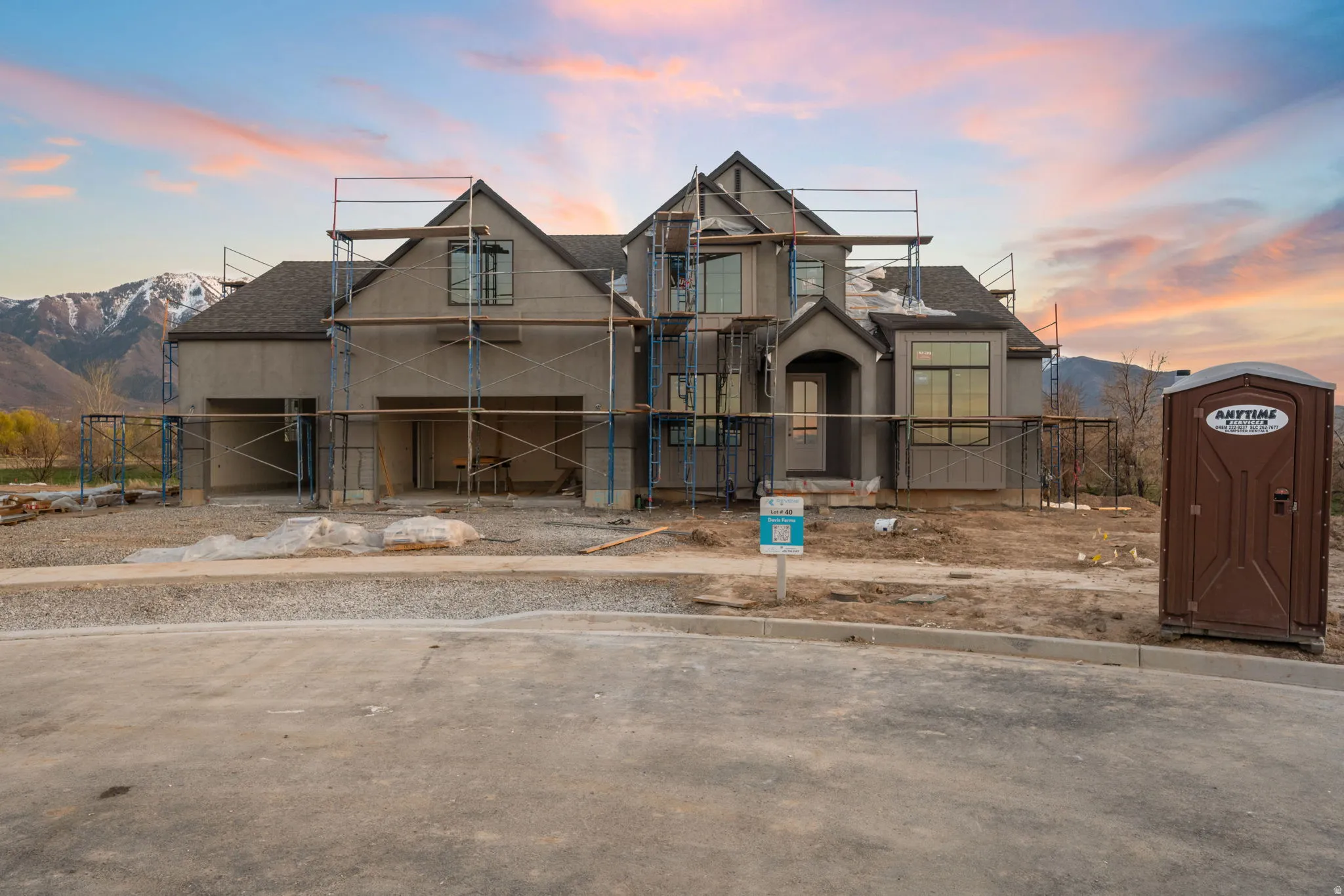Unfinished property featuring a shingled roof, a mountain view, and stucco siding
