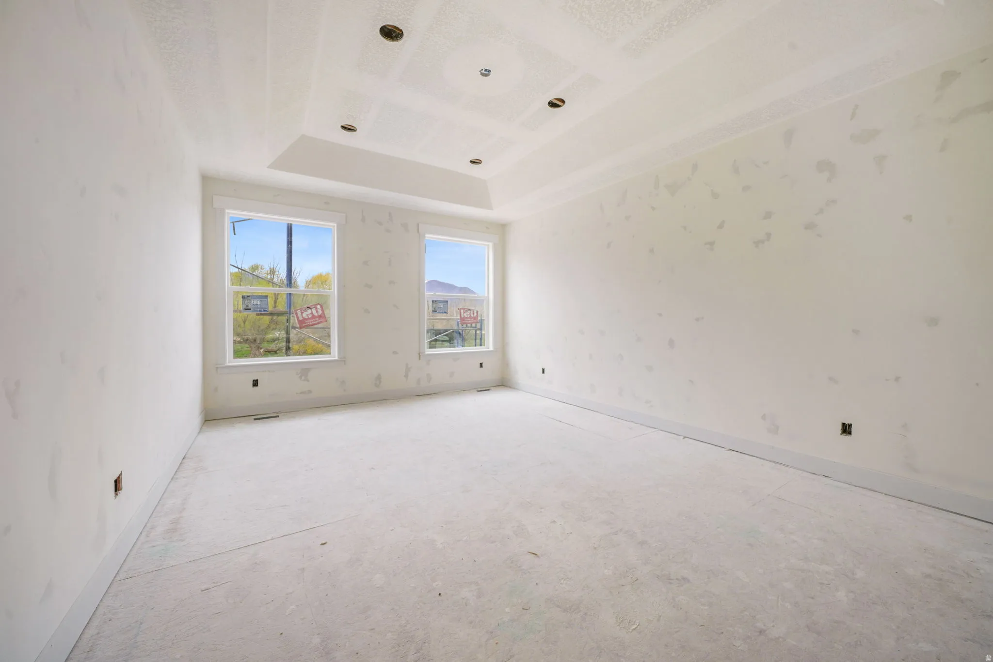 Empty room with a raised ceiling and baseboards