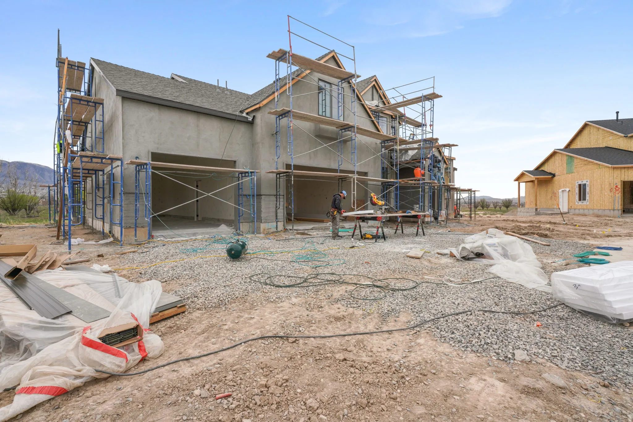 Back of house featuring stucco siding and a shingled roof