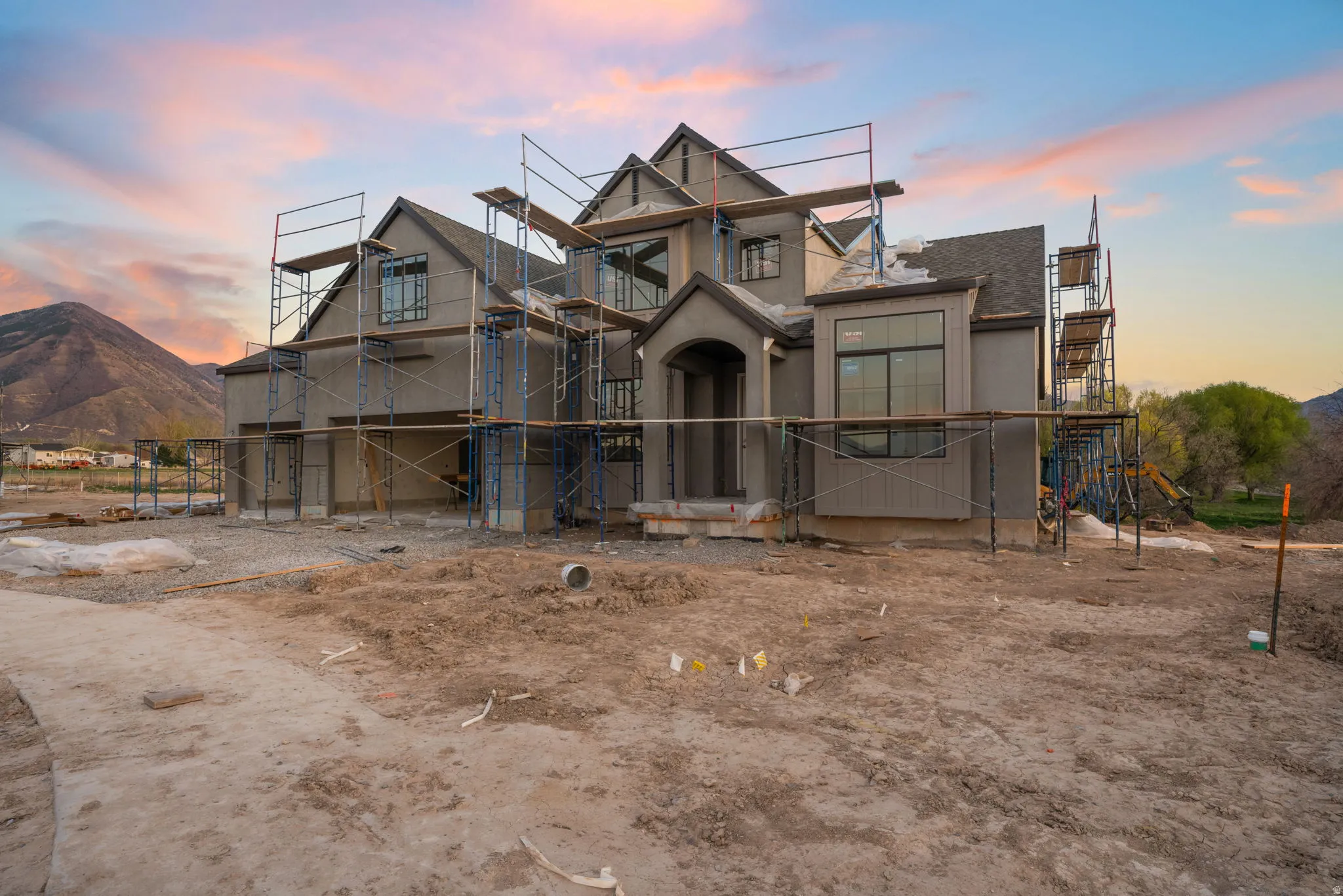 Property in mid-construction featuring a mountain view, stucco siding, and a shingled roof