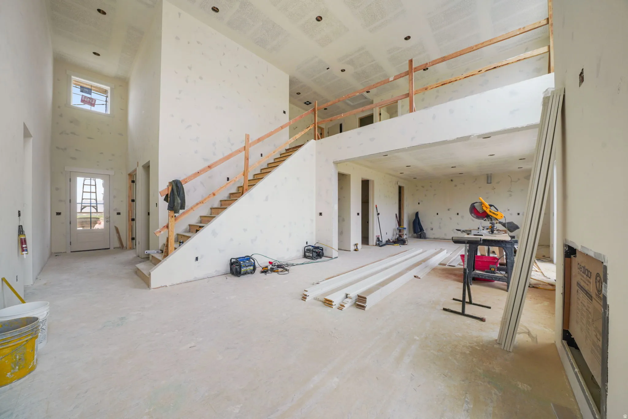 Living room featuring a high ceiling and stairs