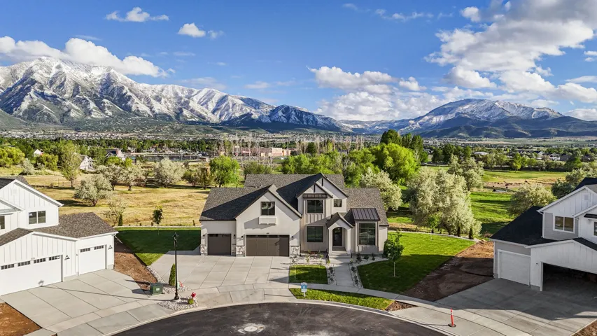Contemporary two-story residence featuring a two-car garage, stone and stucco exterior, and a dark shingle roof