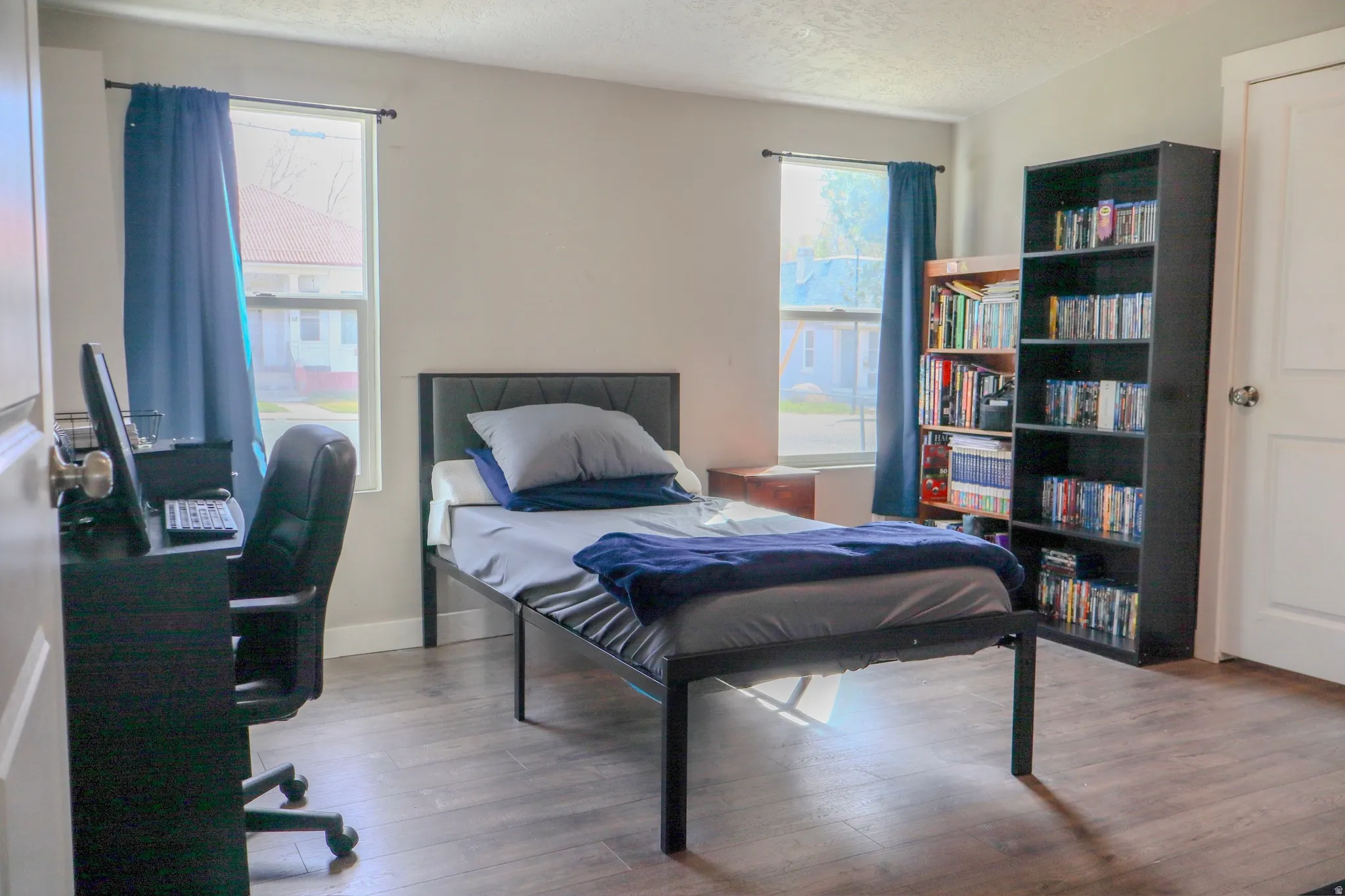 Primary bedroom featuring wood-style flooring, vaulted ceilings, walk-in closet, and an en-suite bathroom.