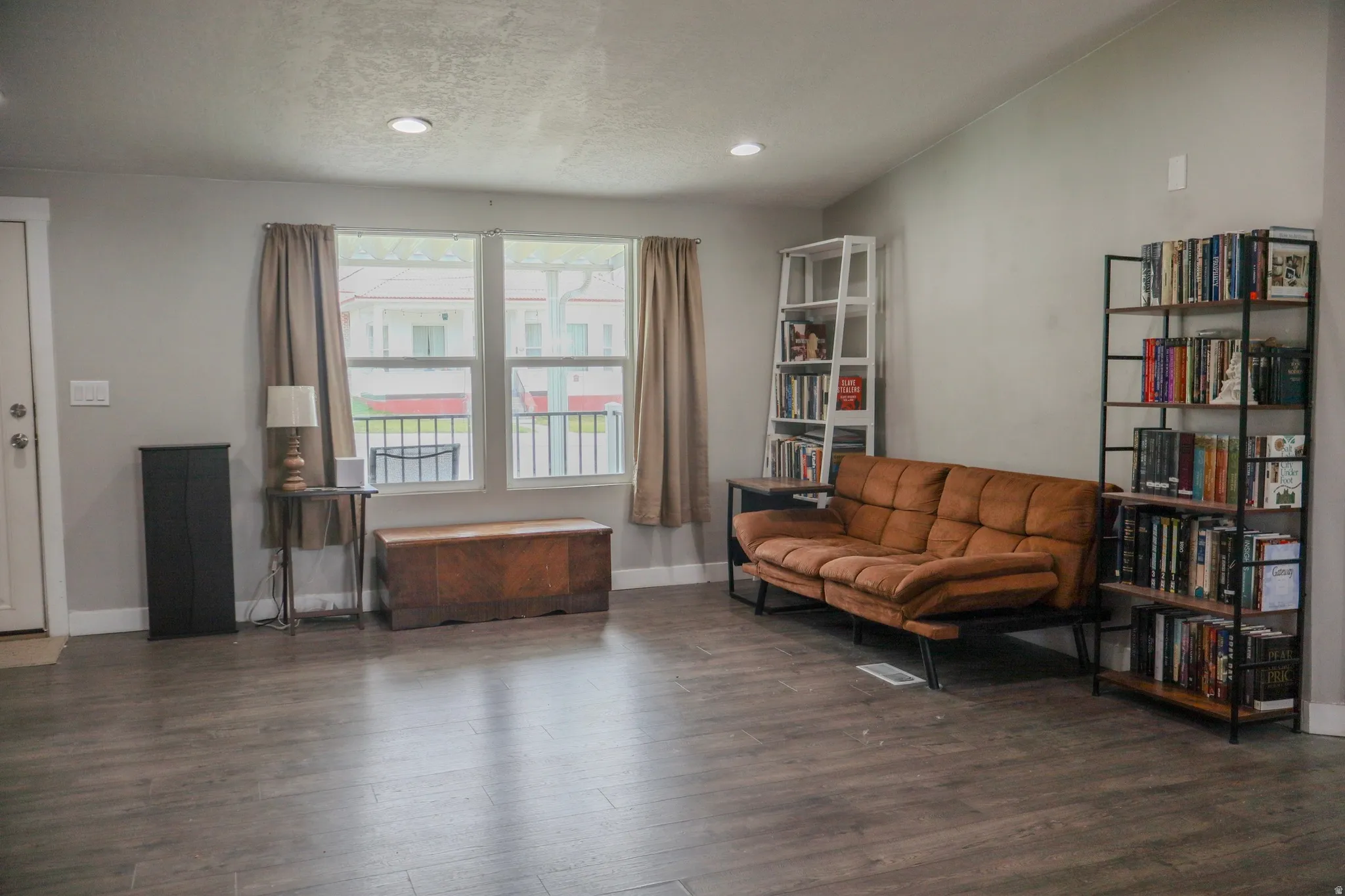 Sitting room open to the dining area featuring wood-style flooring, recessed lighting, and vaulted ceilings.
