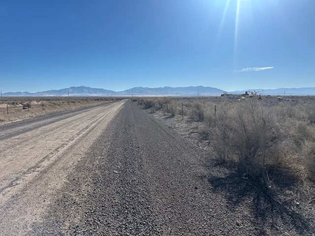 View of dirt / gravel road featuring a mountain view and a view of rural / pastoral area