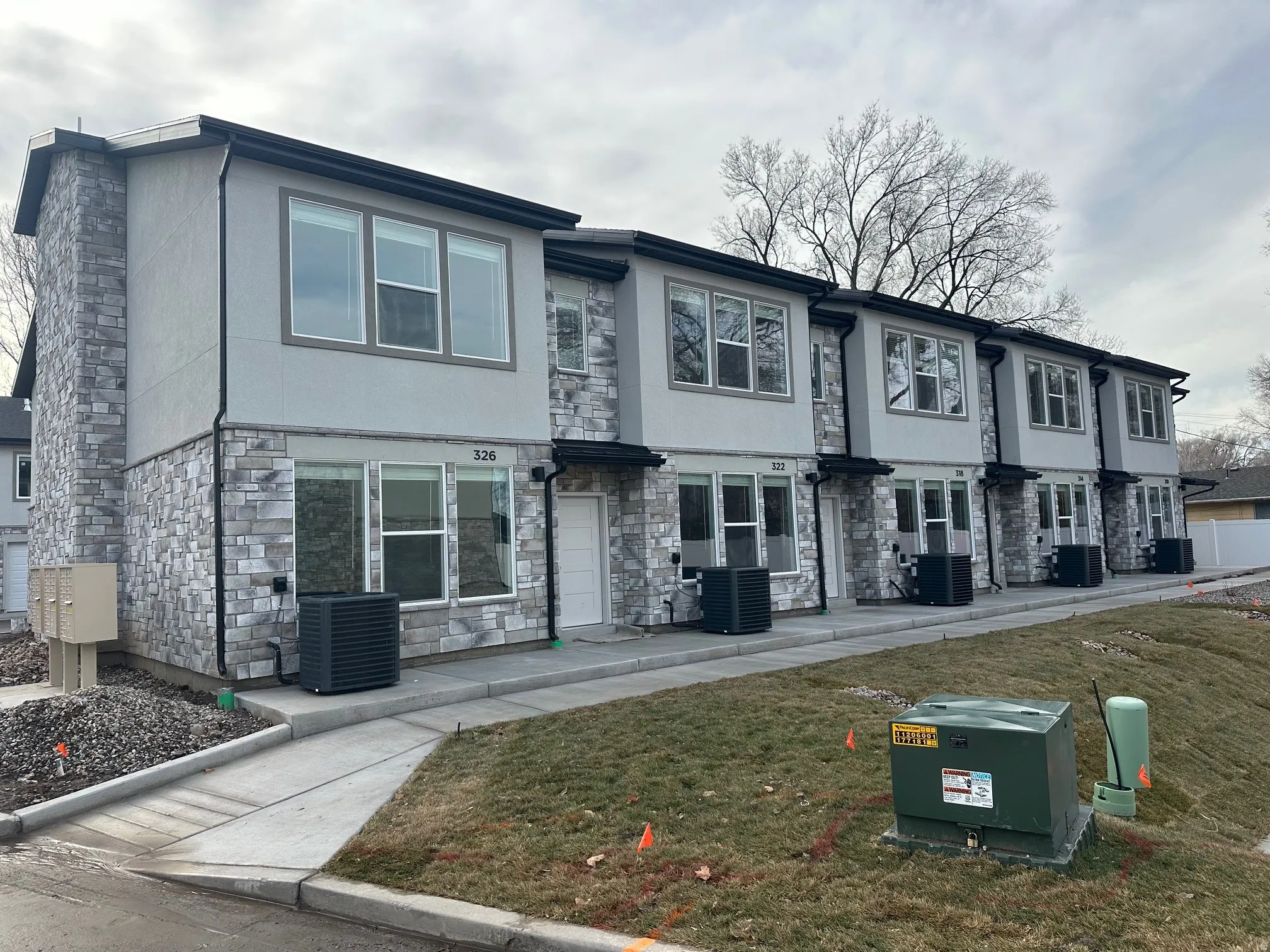 View of front facade featuring stone siding, stucco siding, and a front yard