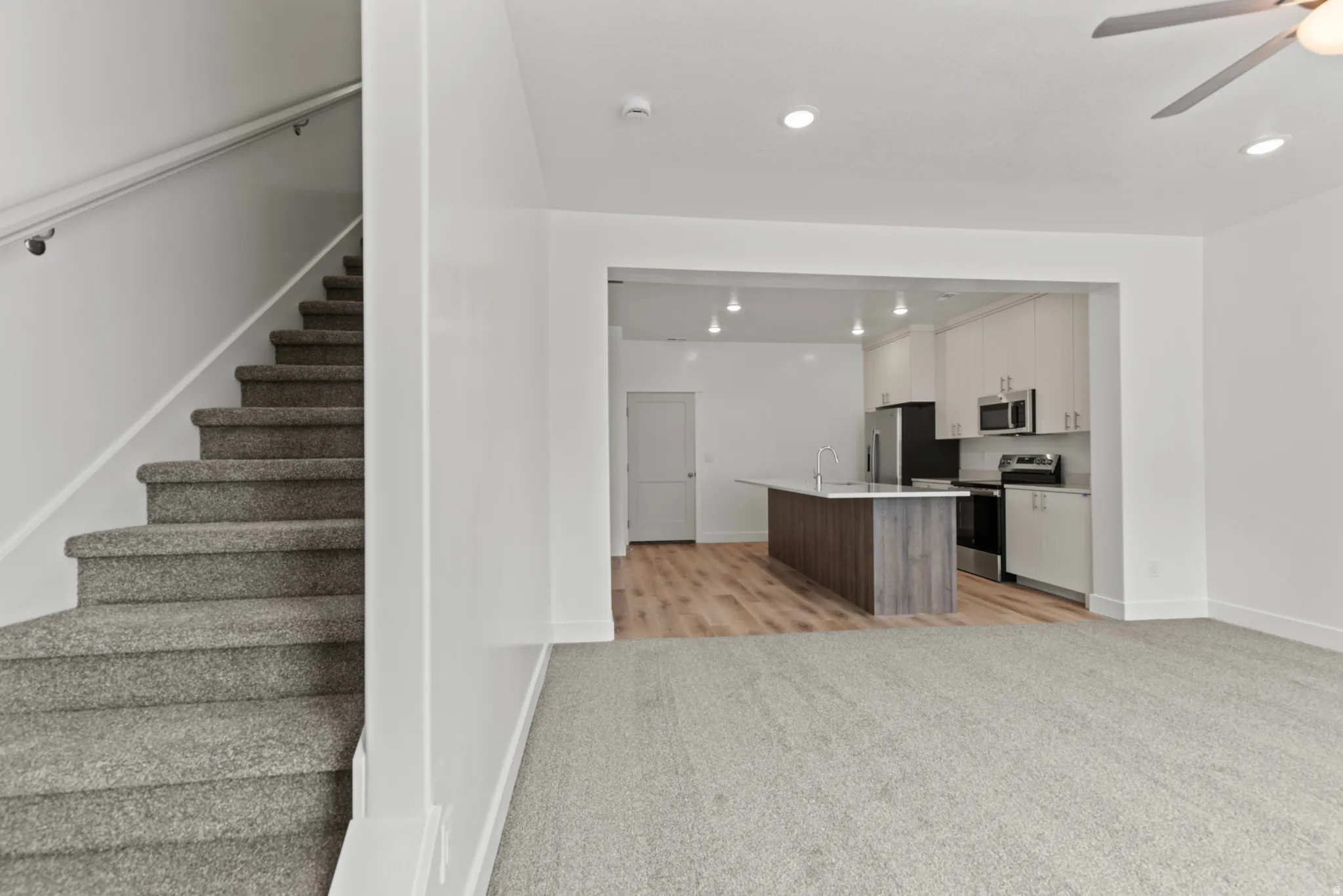 Stairs with ceiling fan, carpet floors, and recessed lighting