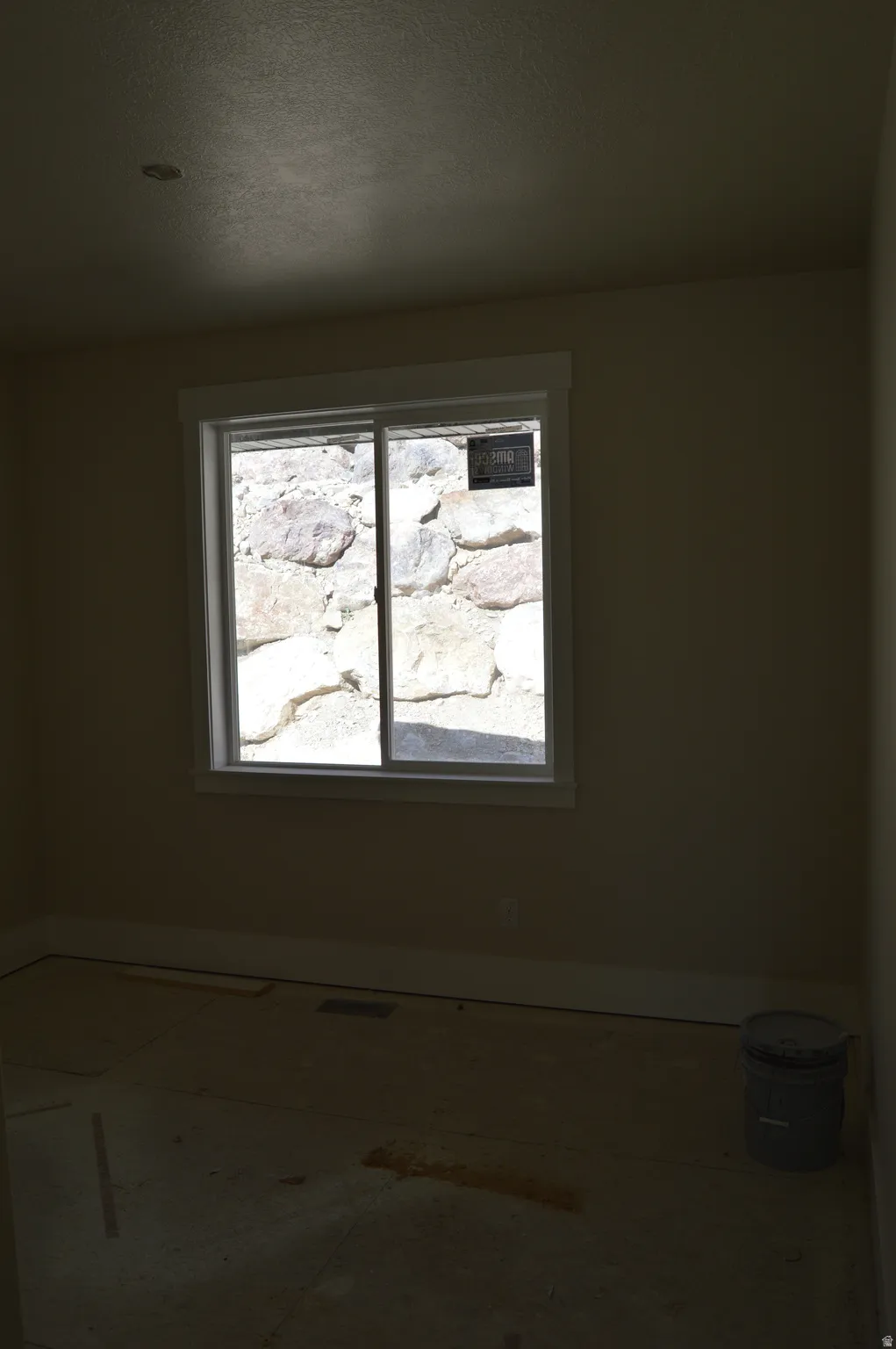 Unfurnished room with baseboards and a textured ceiling