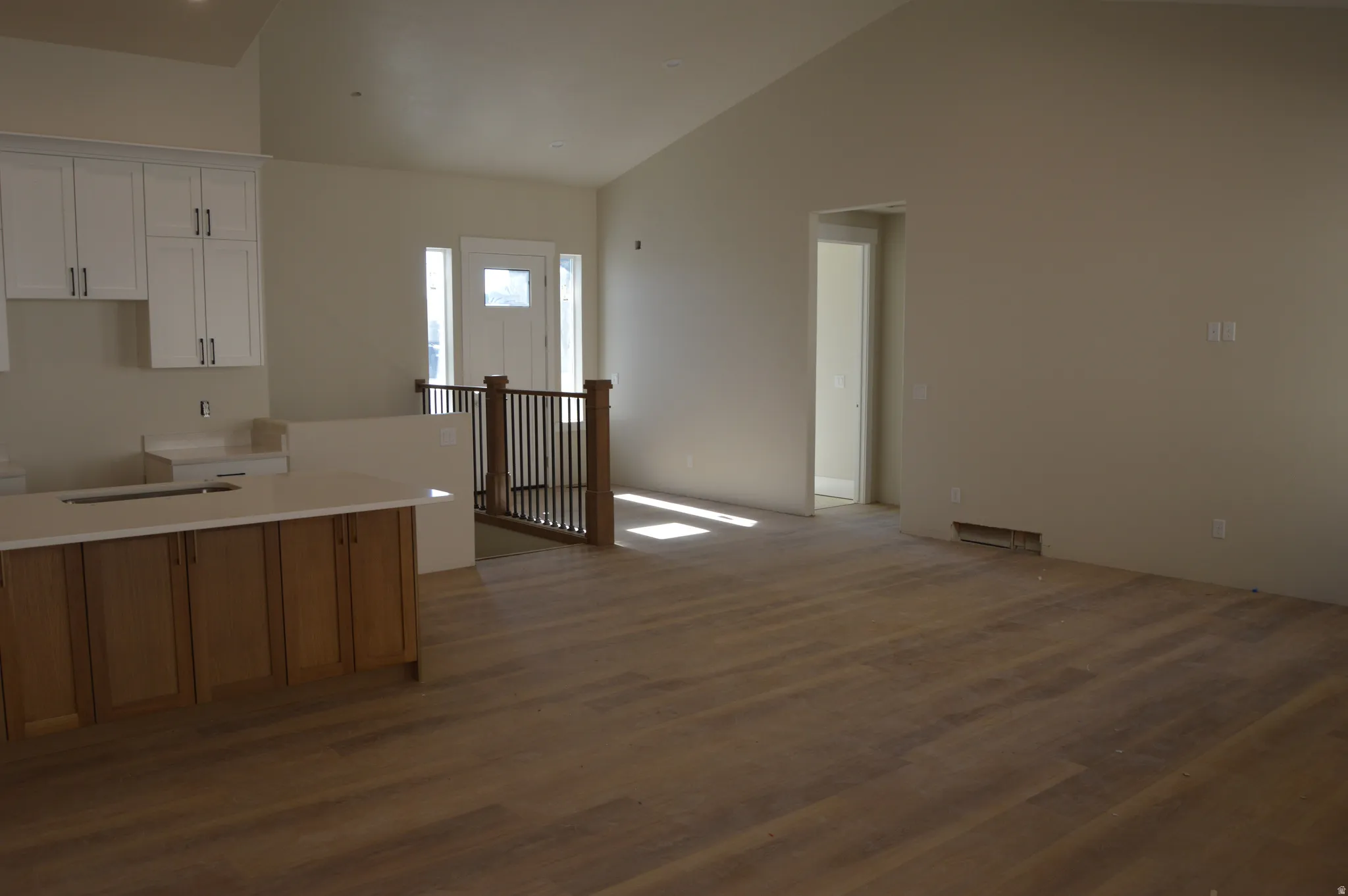 Kitchen featuring white cabinetry, vaulted ceiling, and dark wood finished floors