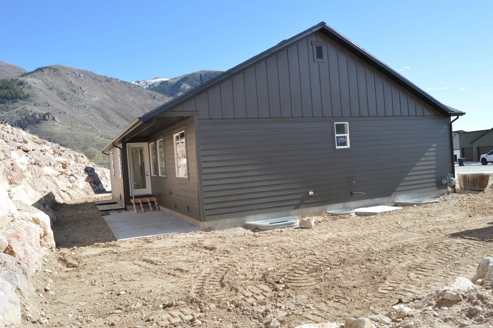View of side of property featuring board and batten siding, a patio area, and a mountain view