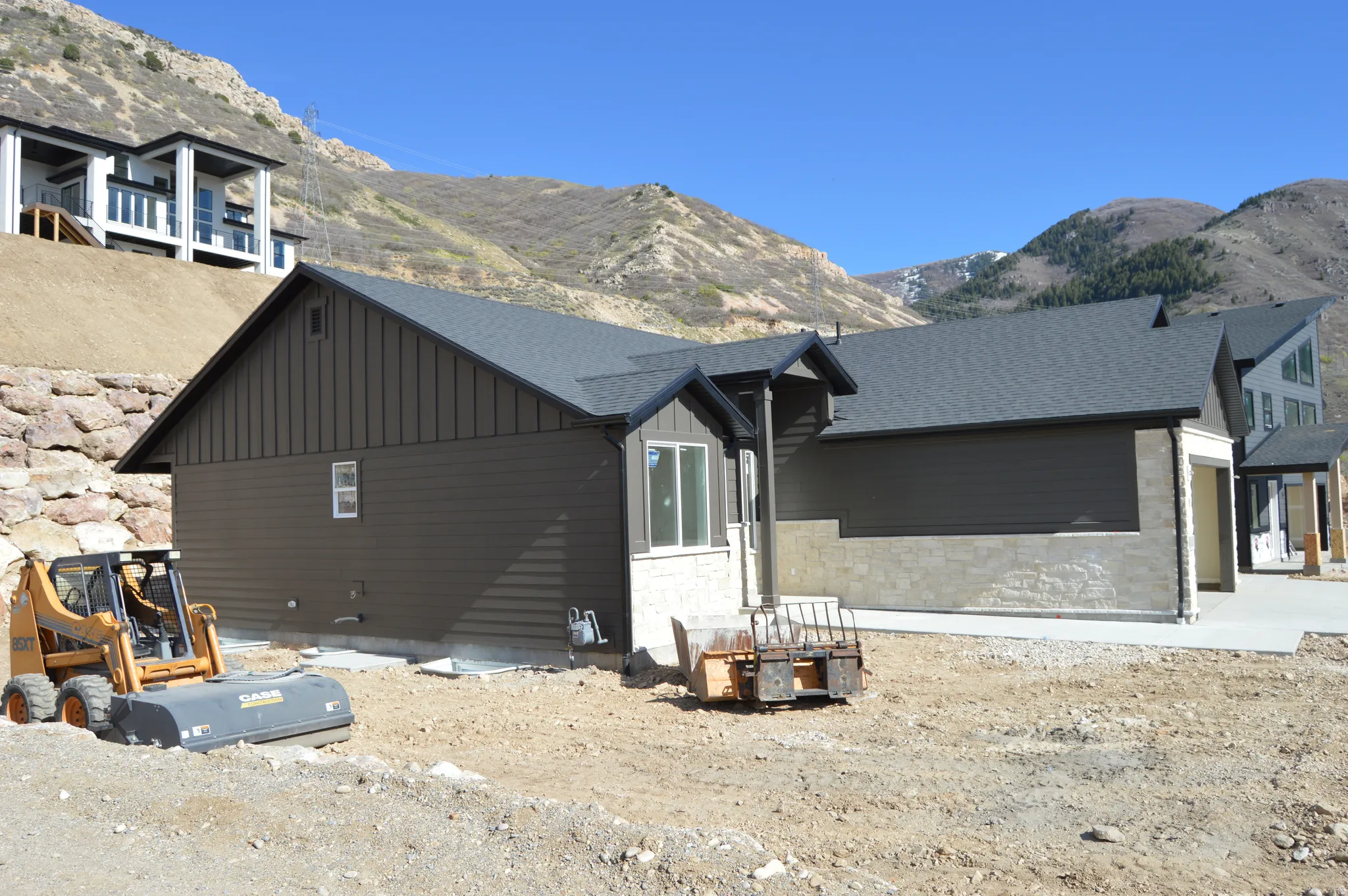 View of home's exterior featuring board and batten siding, a mountain view, stone siding, and a shingled roof