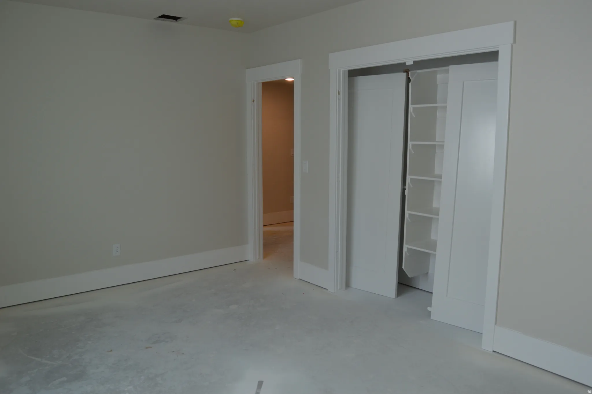 Unfurnished bedroom with a closet and concrete flooring