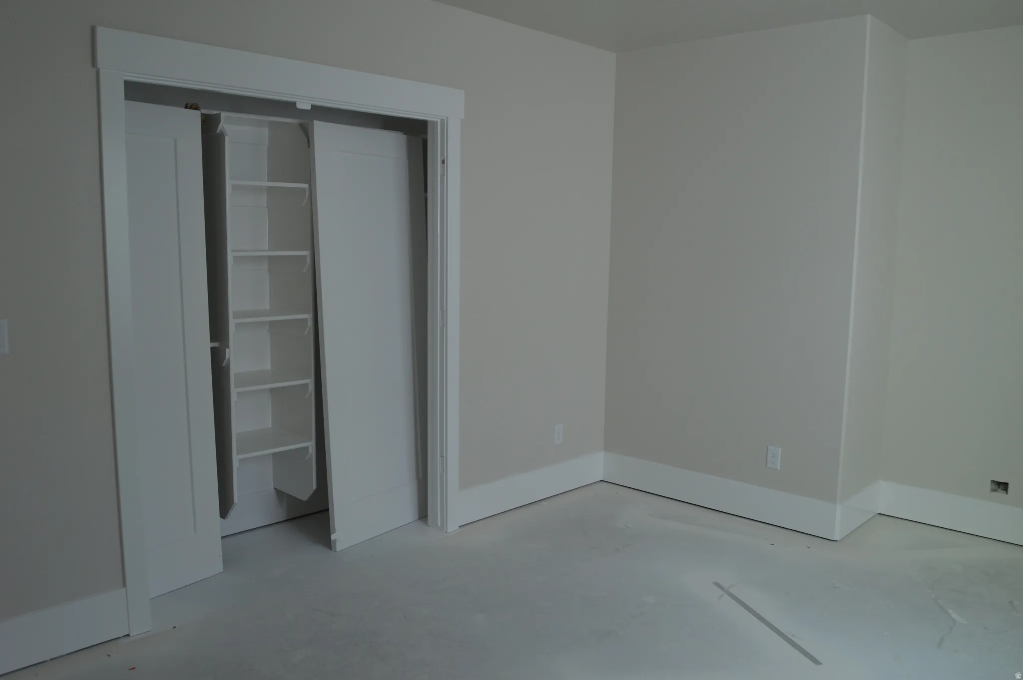 Unfurnished bedroom featuring concrete flooring and a closet