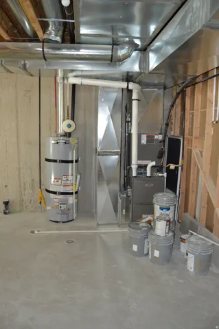 Concrete flooring, exposed ductwork, water heater, furnace, unfinished wall framing