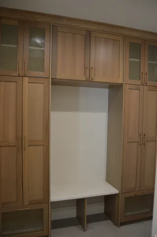 Built-in cabinetry with wood-finish doors and metal mesh accents