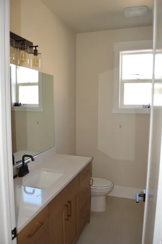 Wood-finish vanity with gold-tone hardware, integrated sink, and dark-finish faucet