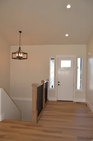 Wood-finish flooring, recessed lighting, and a decorative chandelier