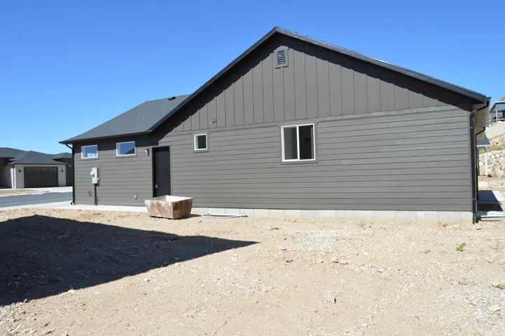 Exterior featuring dark gray siding, a dark gray roof, and white window frames