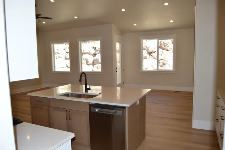 Kitchen island with an undermount sink, a gooseneck faucet, and a stainless steel dishwasher