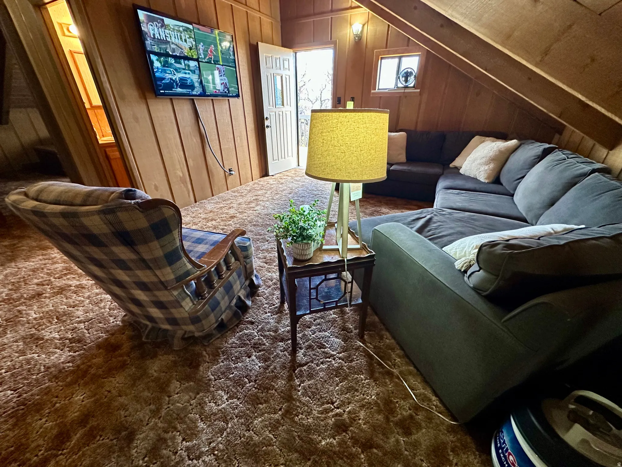 Living room featuring wooden walls and vaulted ceiling