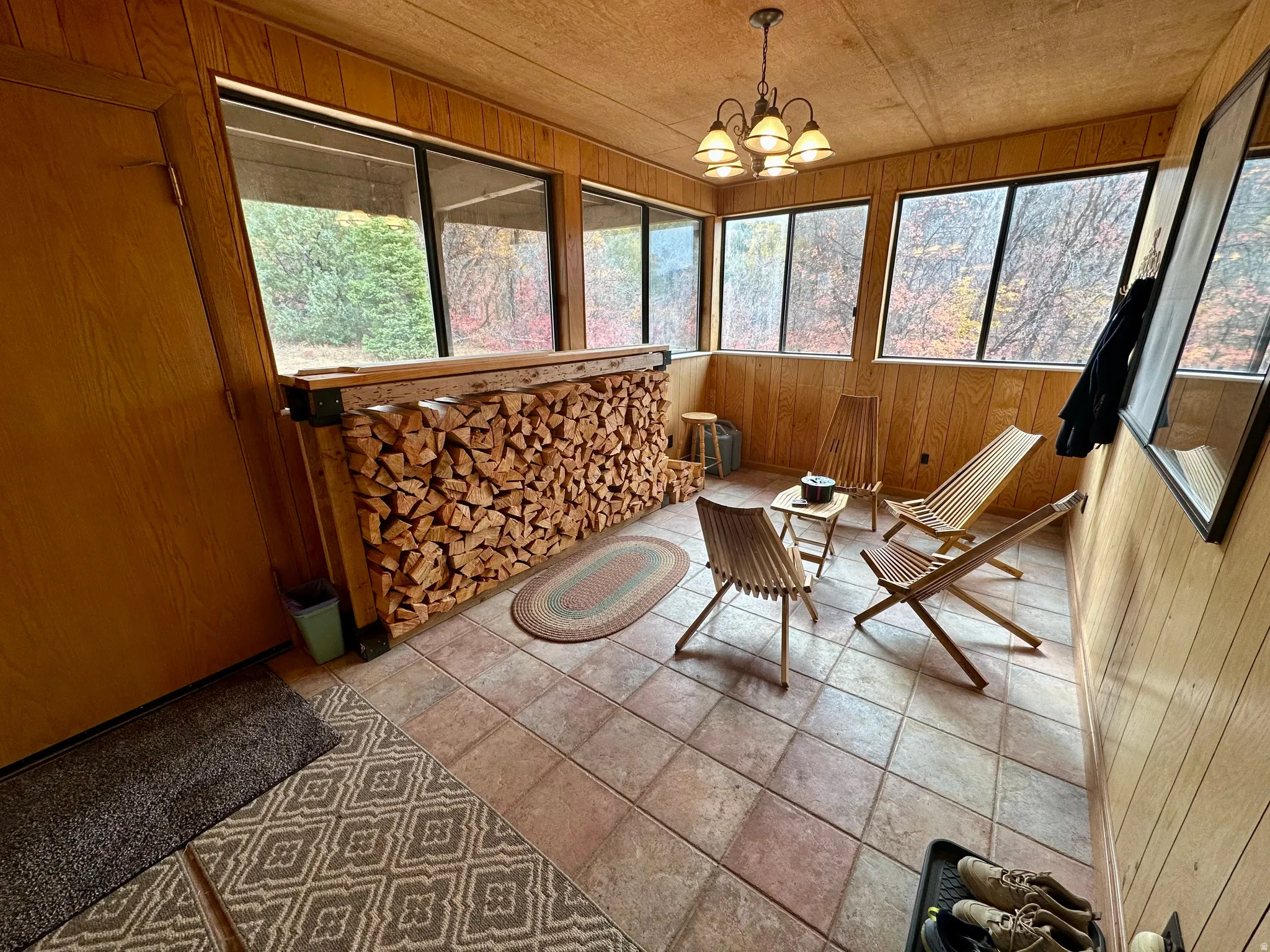 Sunroom with wood walls and a chandelier