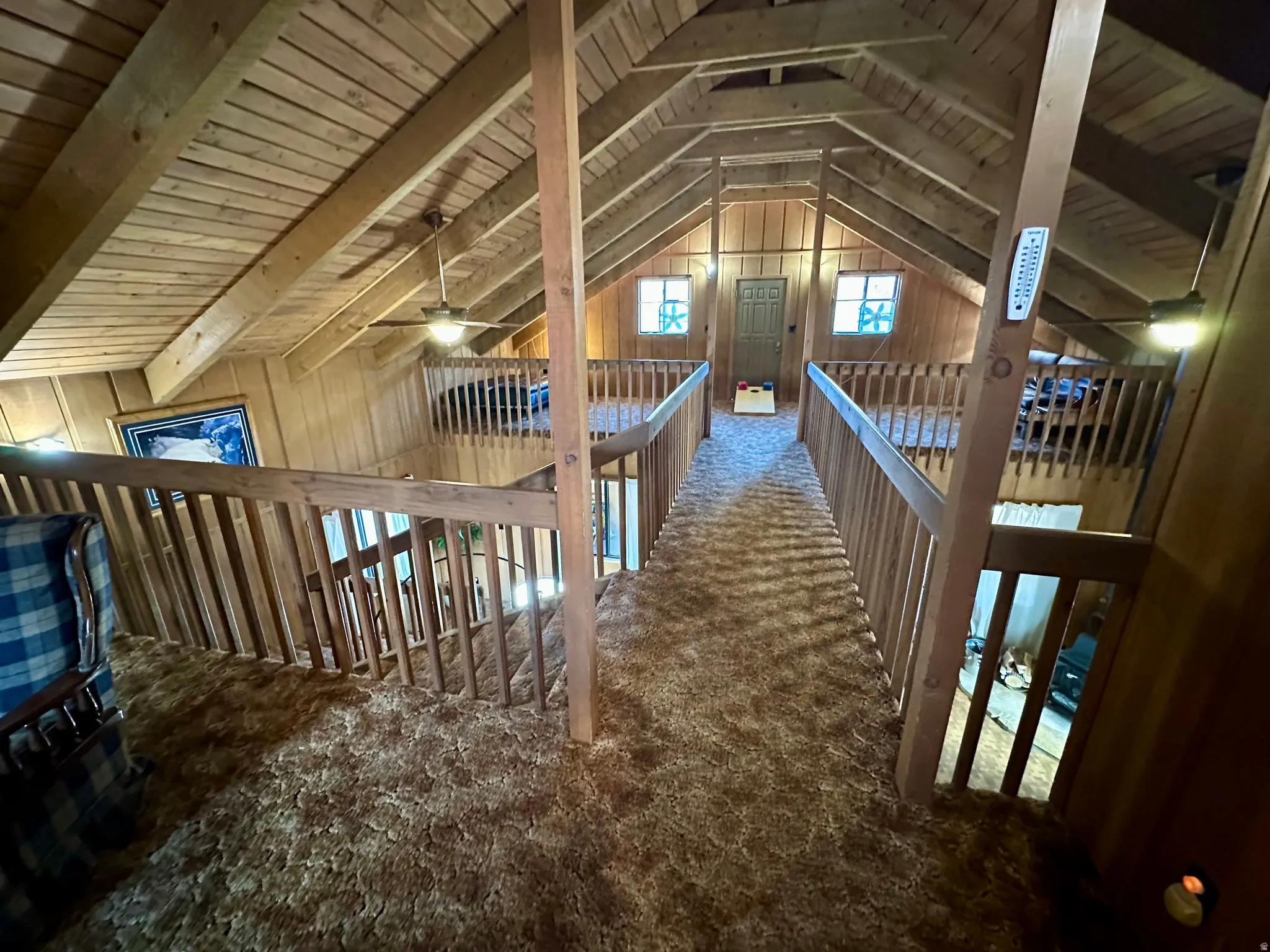 Corridor with a wooden ceiling with exposed beams, wooden walls, and carpet floors