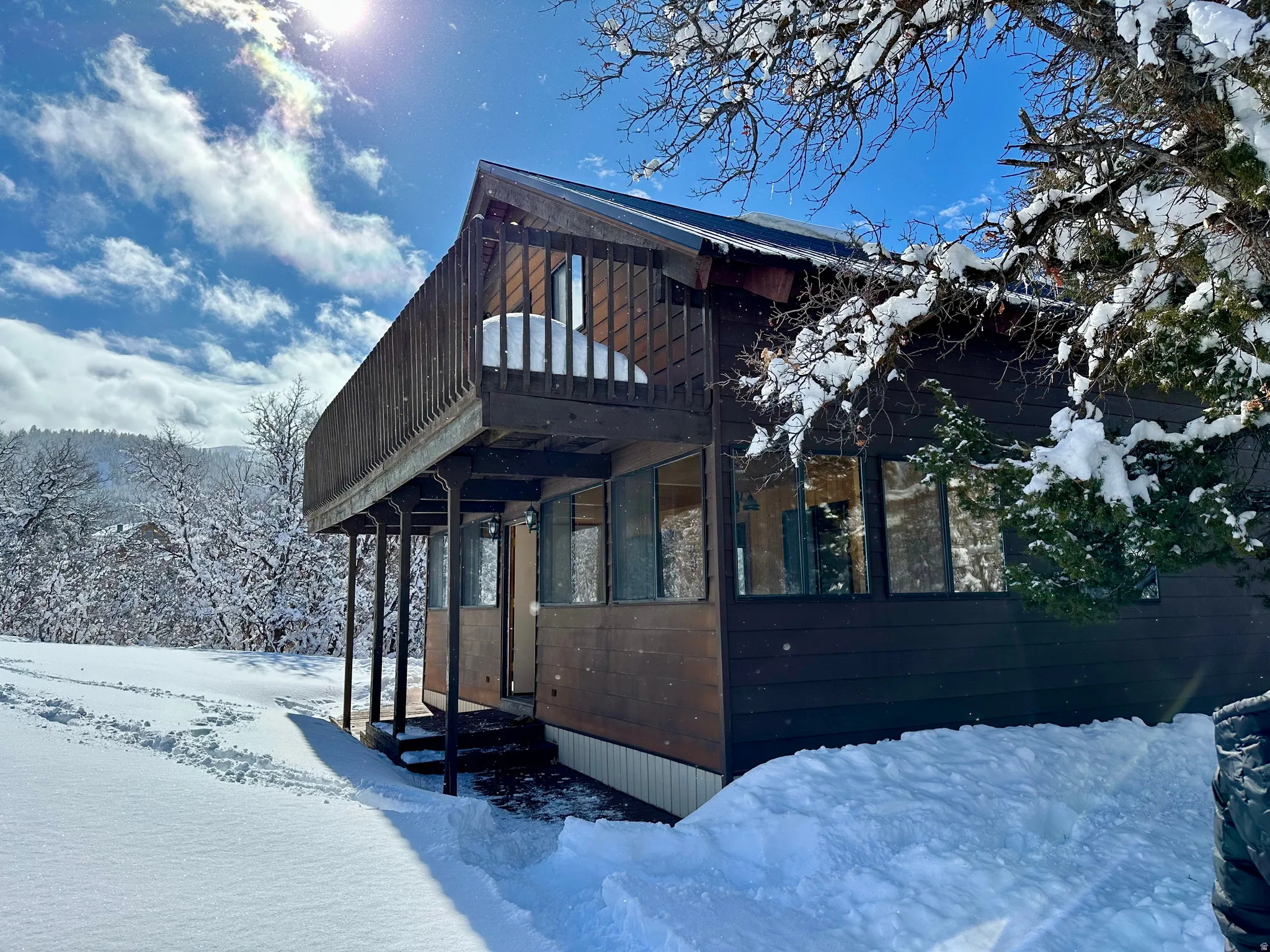 View of snow covered exterior with a deck and a balcony