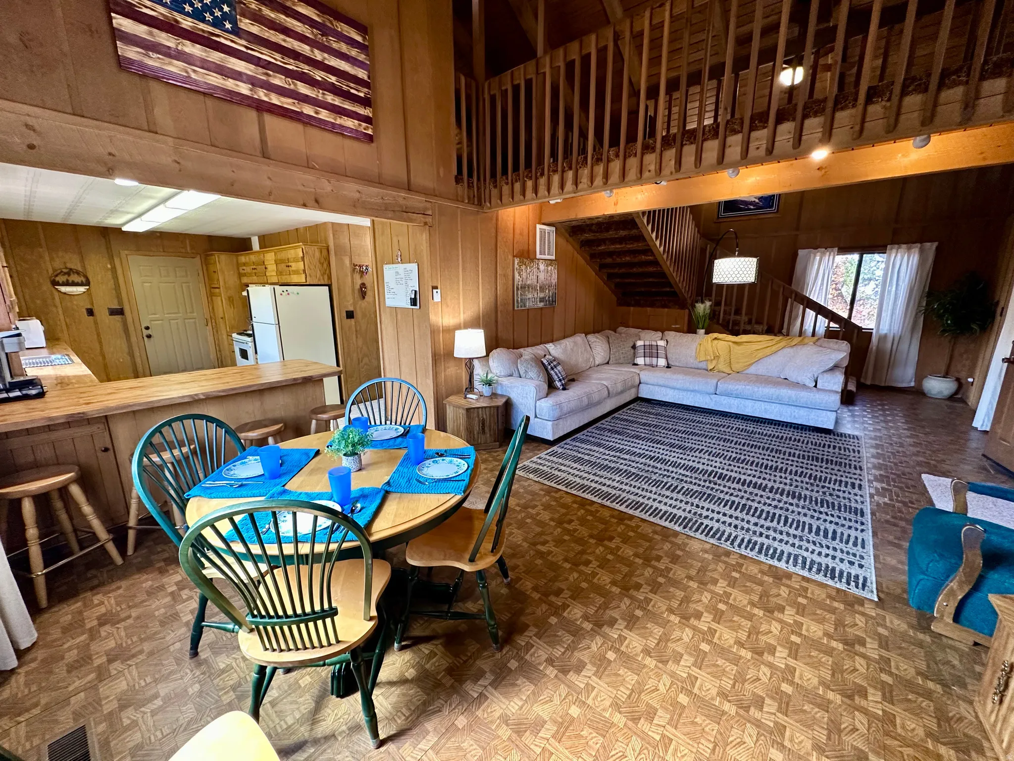 Dining area with wood walls, a high ceiling, and parquet flooring