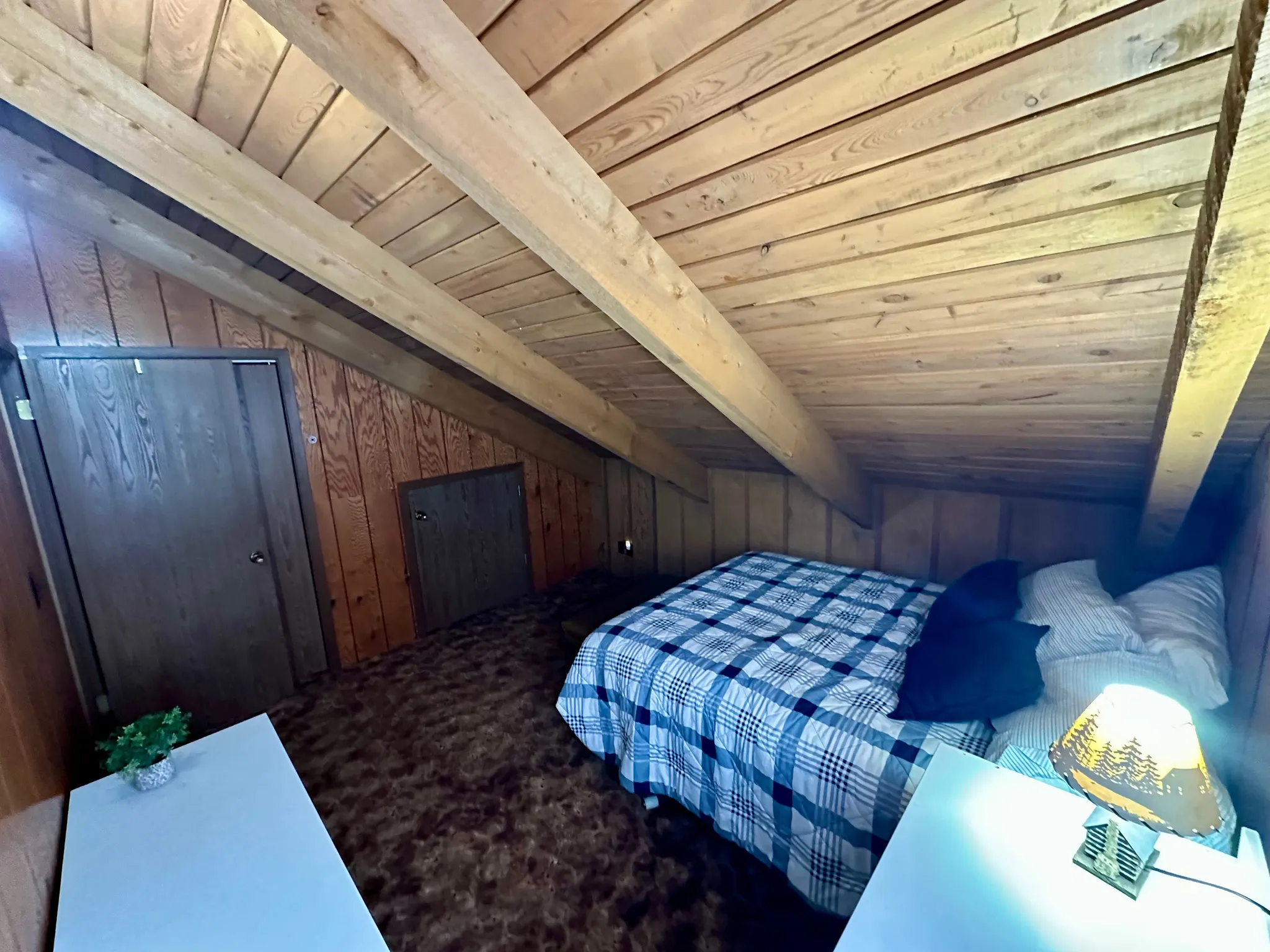 Carpeted bedroom with wooden walls, wood ceiling, and vaulted ceiling with beams