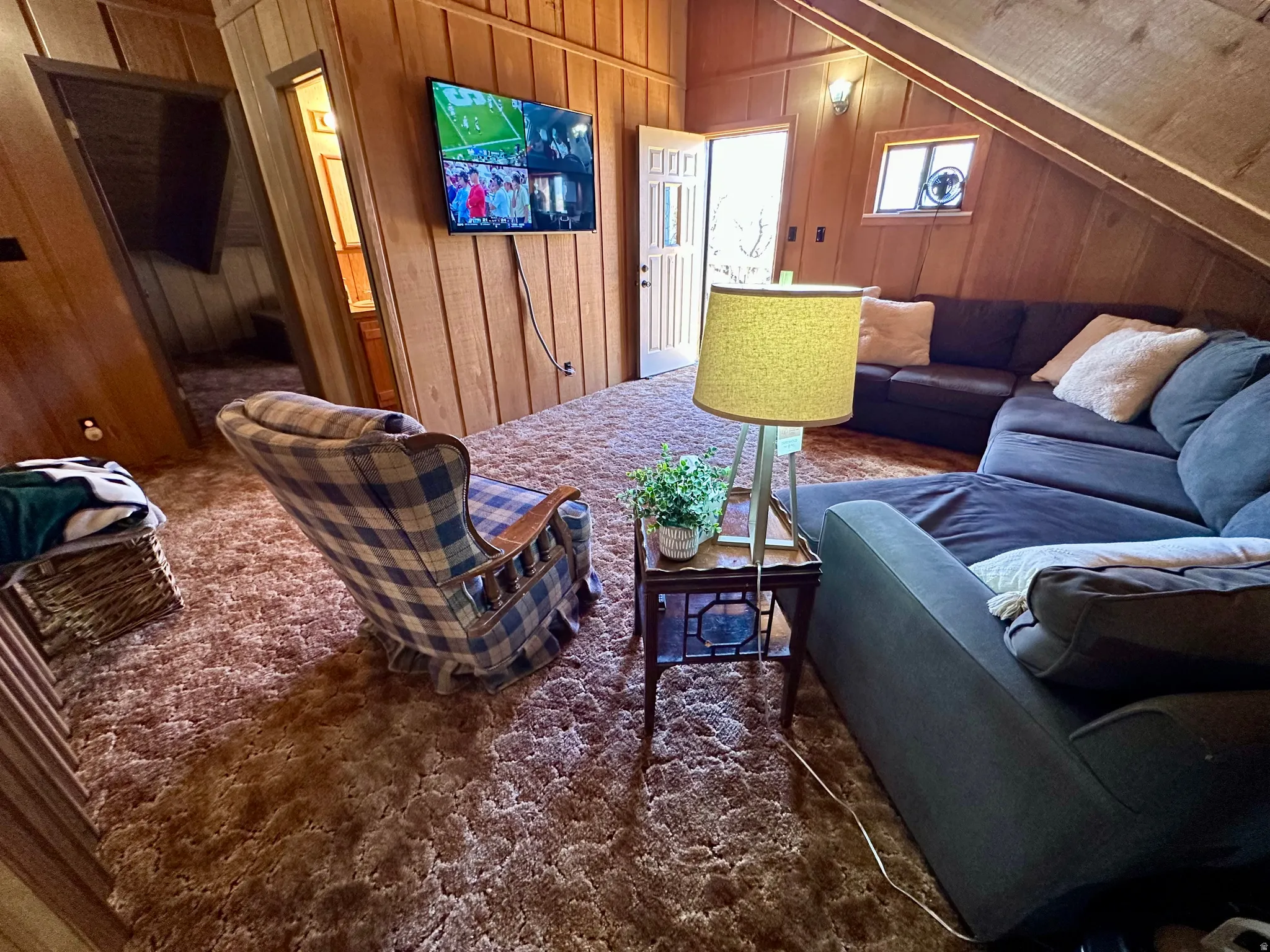 Living room with wood walls and lofted ceiling