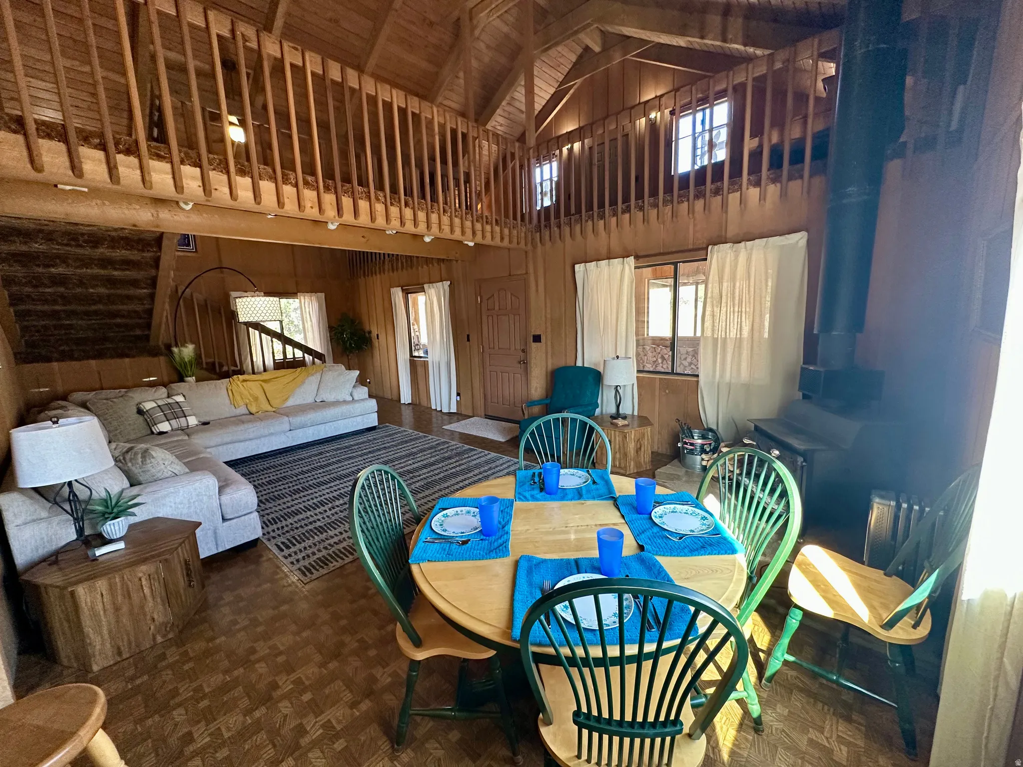 Dining room featuring wooden walls, a high ceiling, and parquet flooring