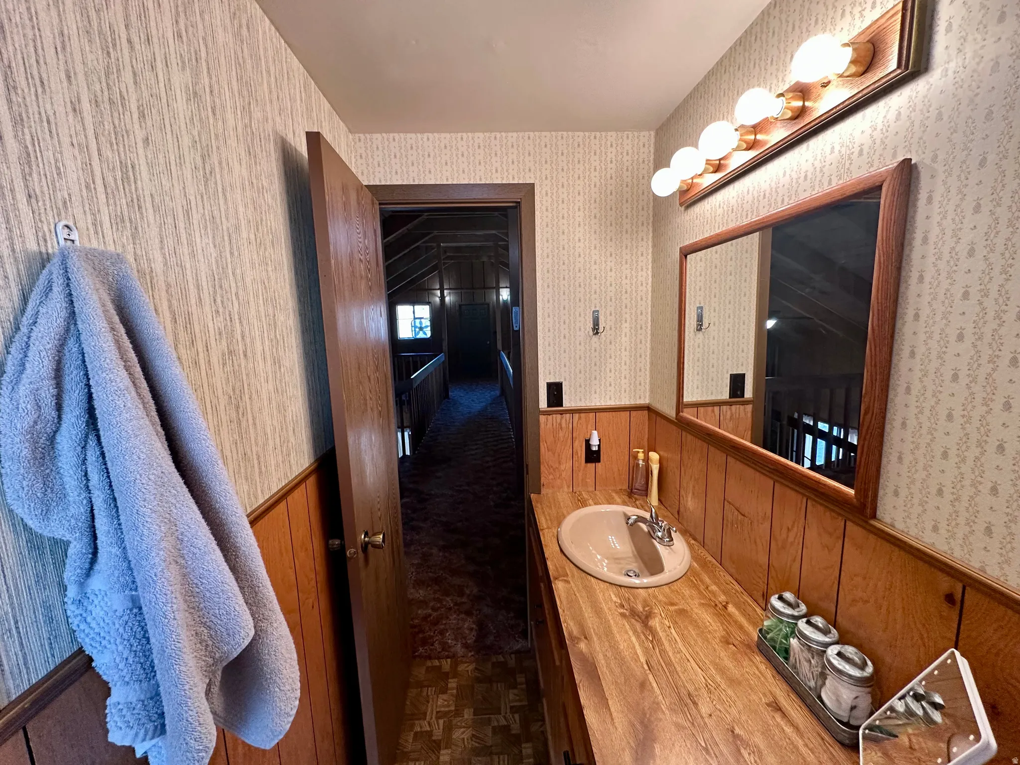 Bathroom with vanity, wainscoting, and wooden walls