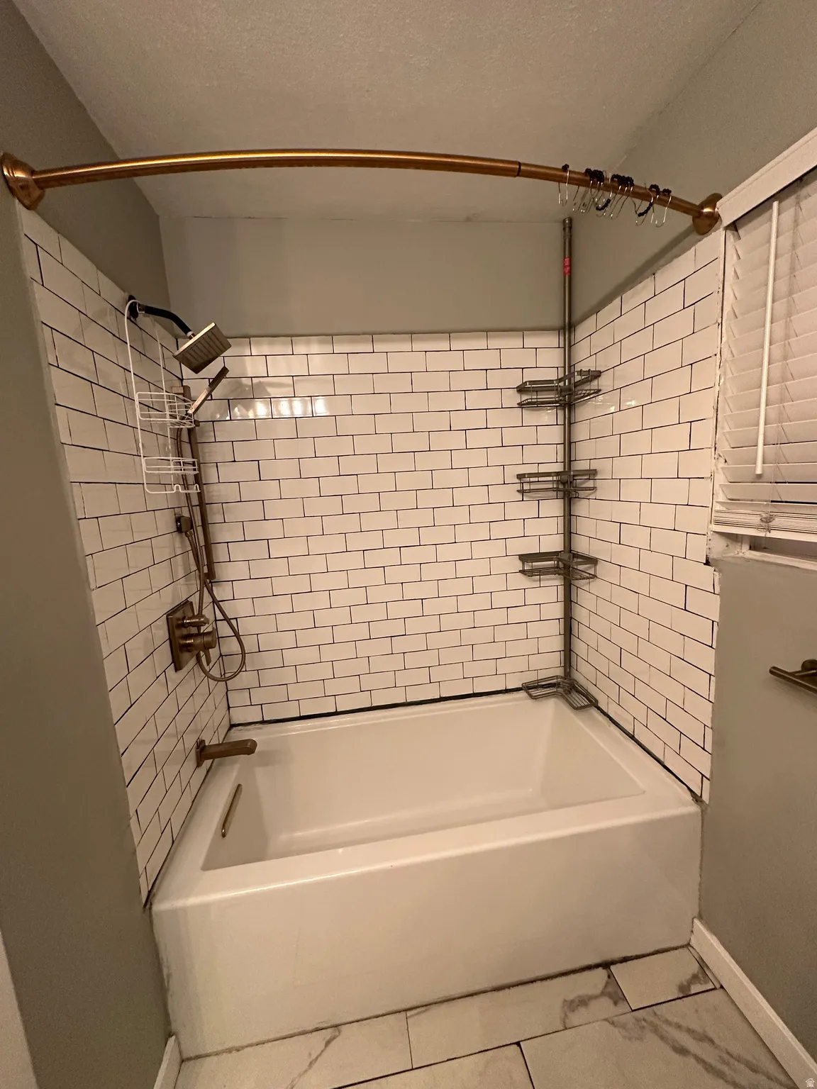Full bath with shower / bathtub combination and a textured ceiling