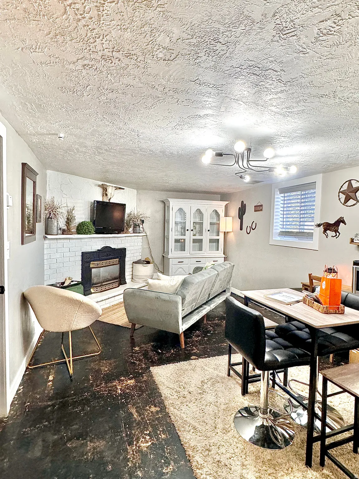 Living room with a brick fireplace and a textured ceiling
