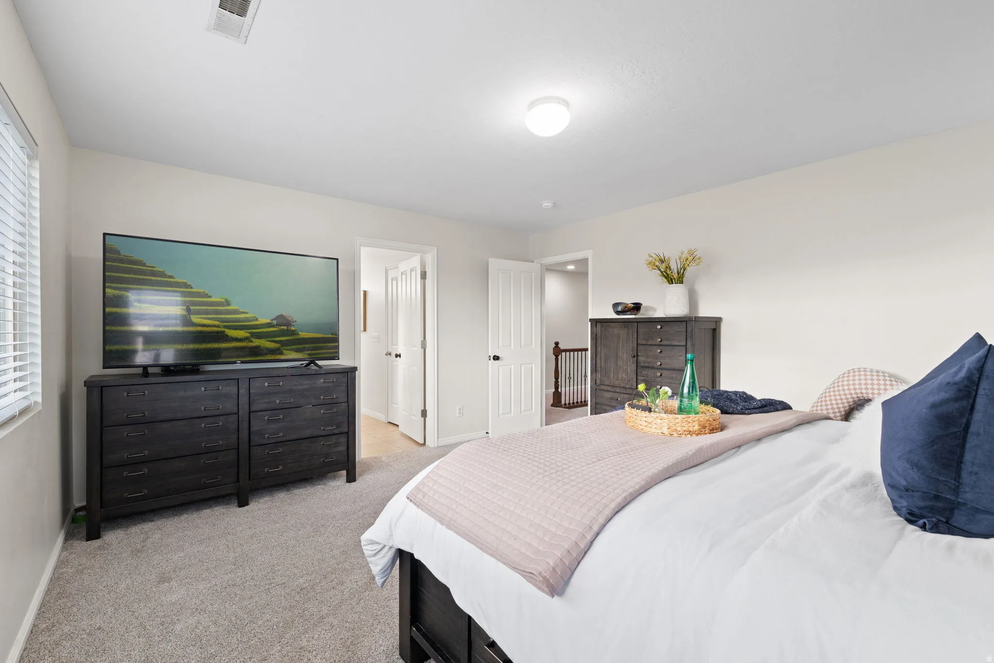 Bedroom featuring light carpet and baseboards