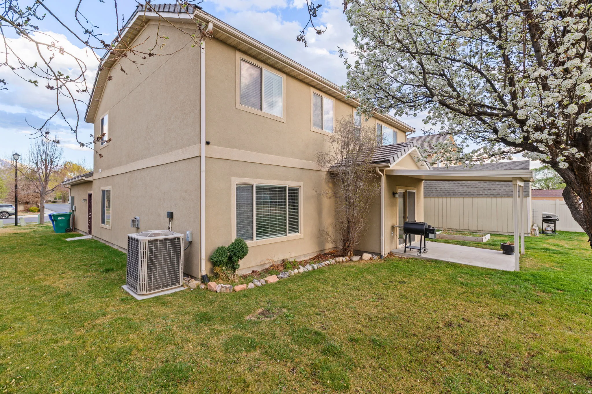 Back of house with a patio area, stucco siding, and a yard