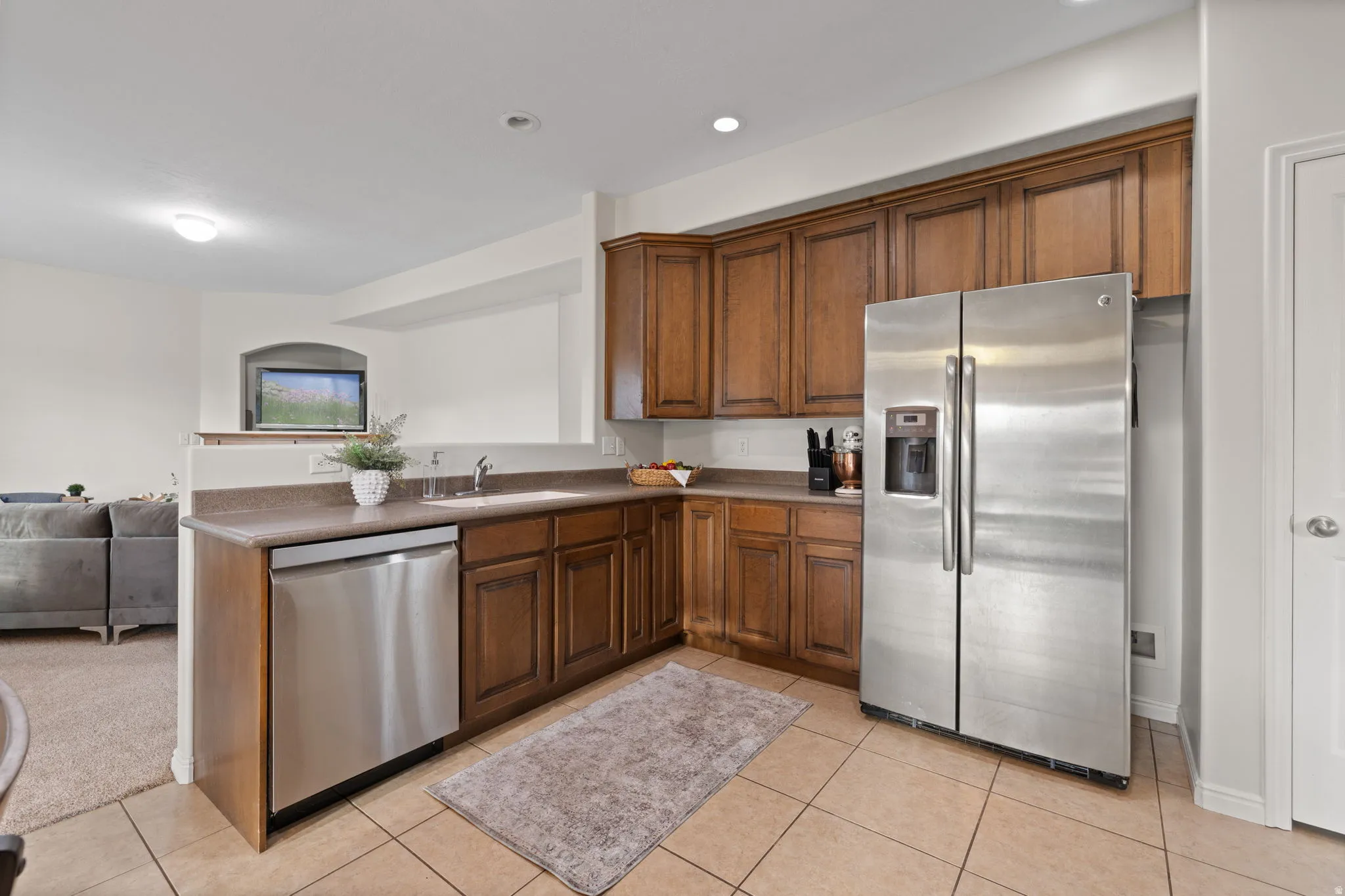 Kitchen with stainless steel appliances, dark countertops, open floor plan, and light tile patterned flooring