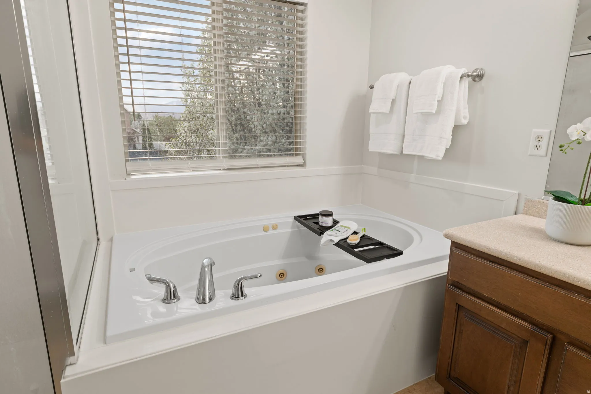 Bathroom featuring a tub with jets and vanity