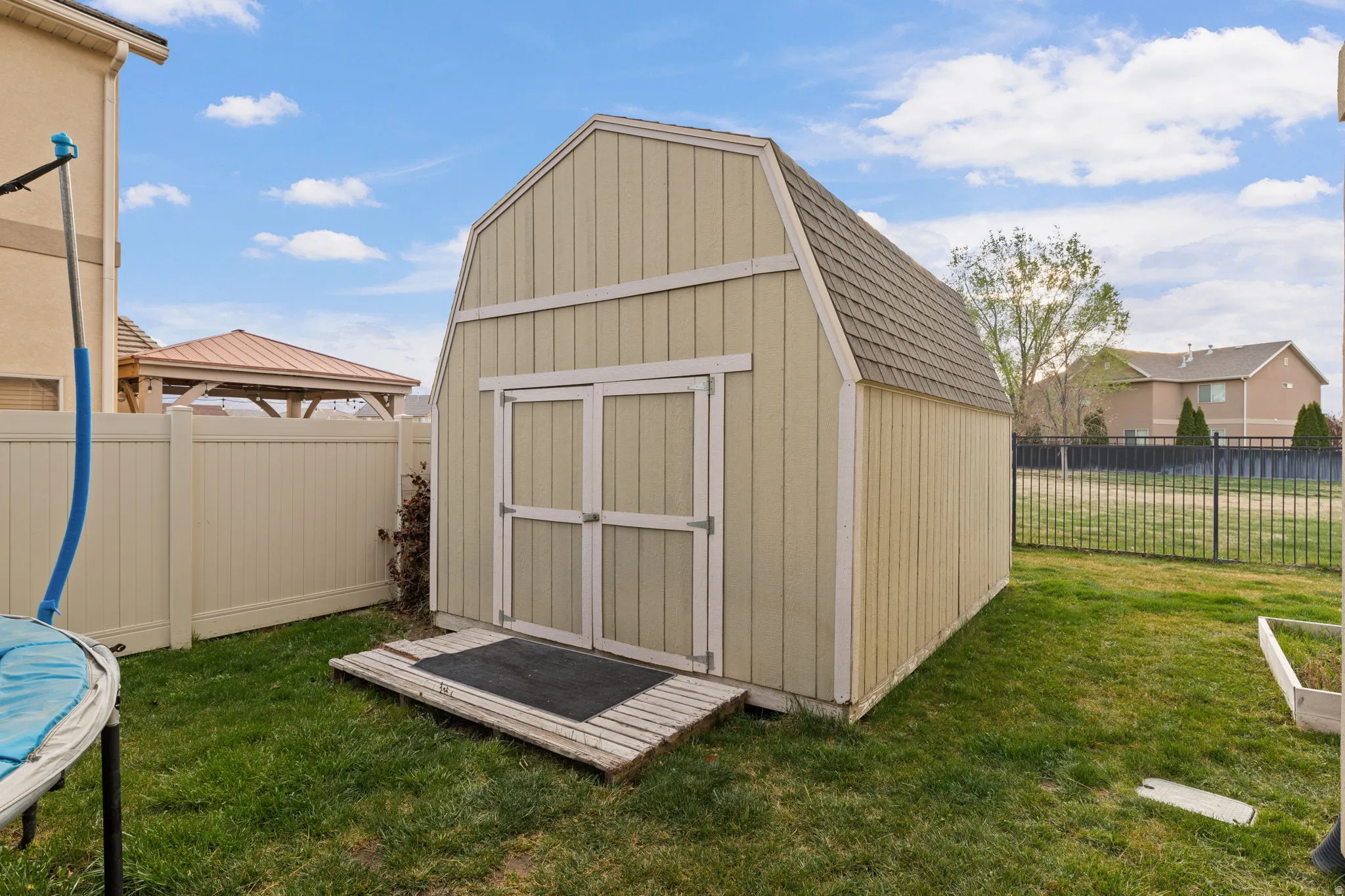 View of shed featuring a fenced backyard and a trampoline