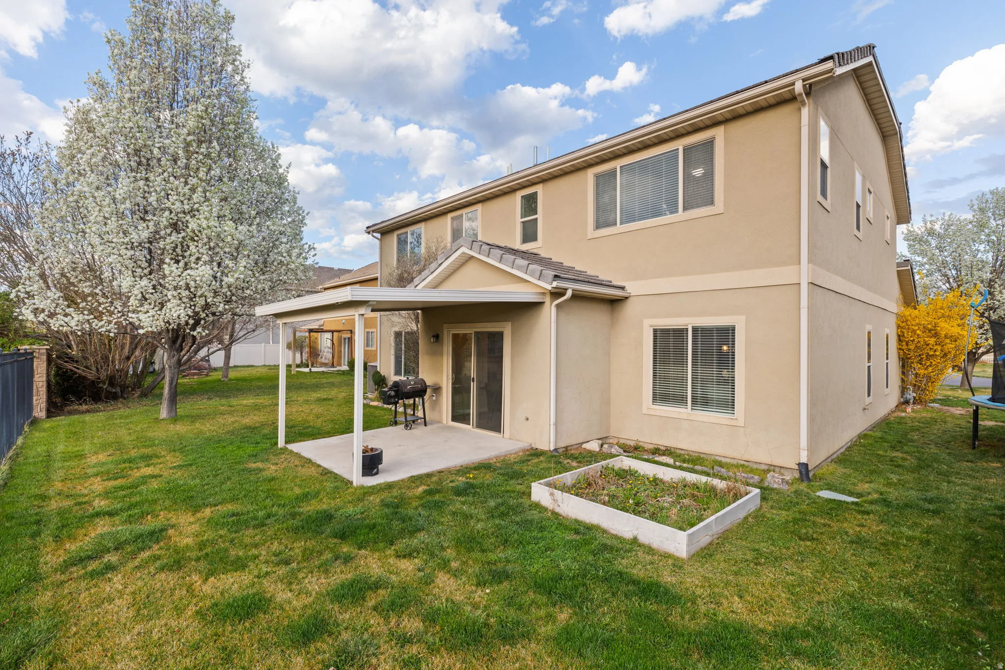 Back of house featuring a patio, stucco siding, and a garden