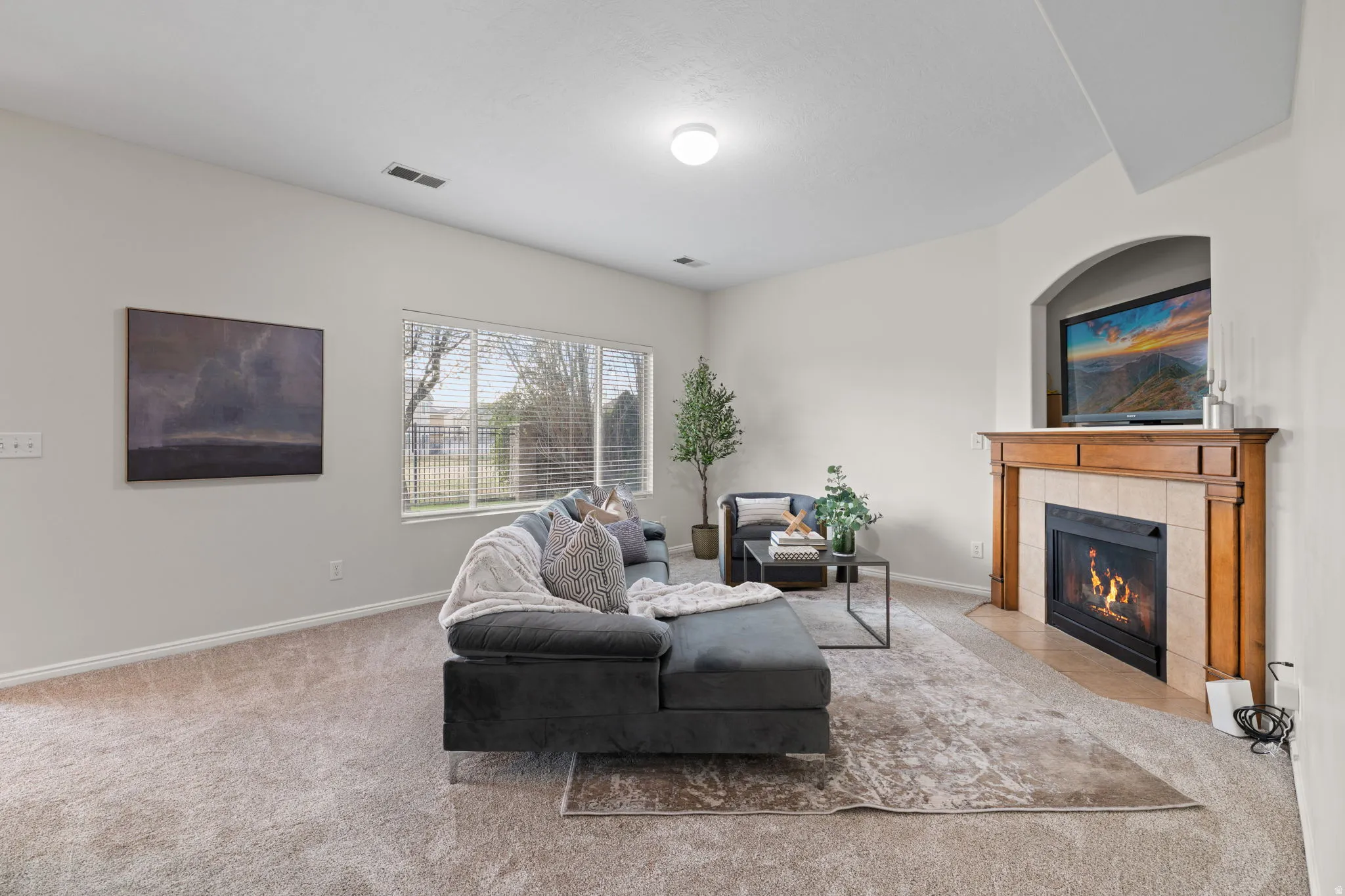 Living room with carpet flooring and a tile fireplace