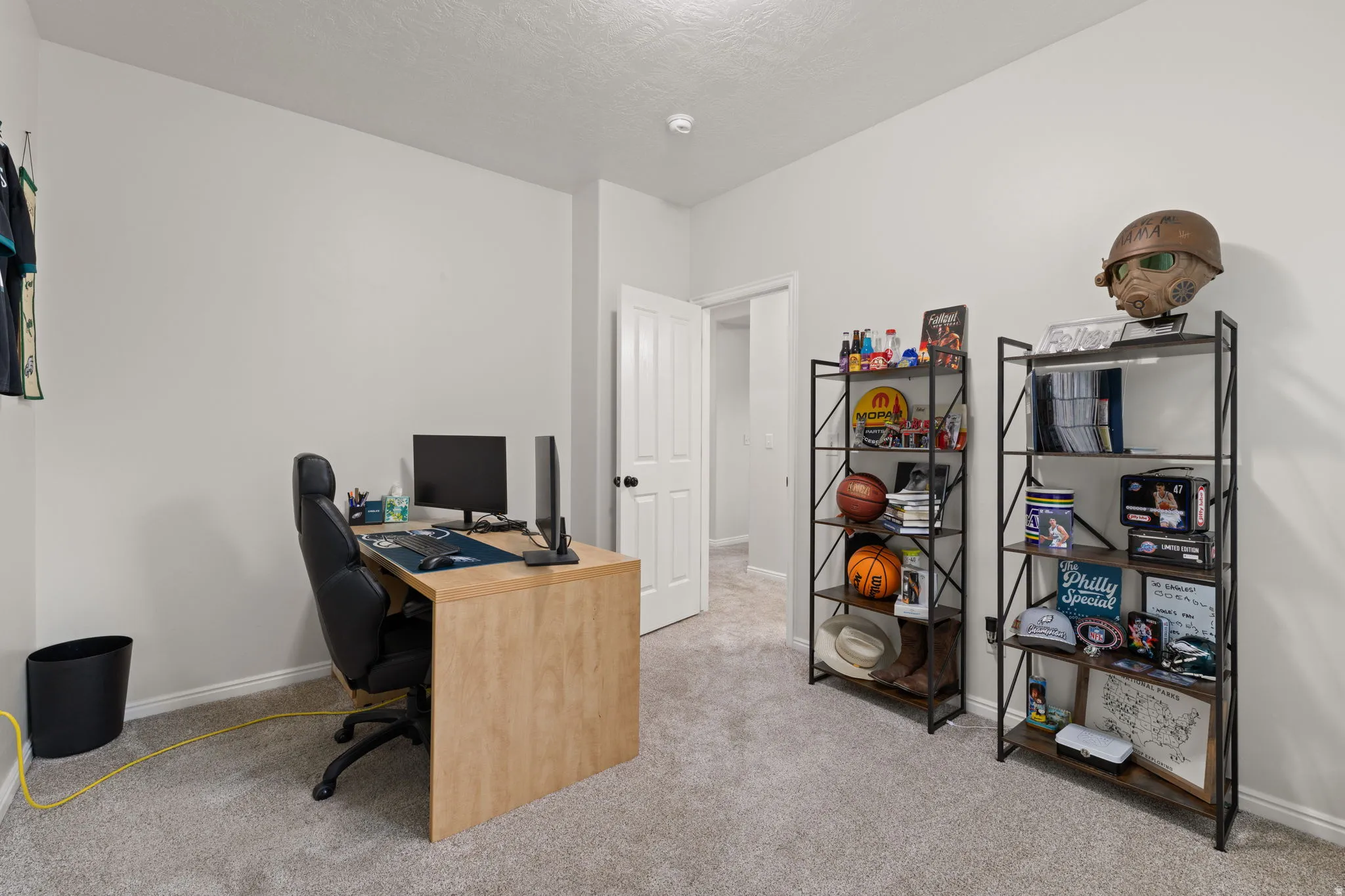 Office with light colored carpet and a textured ceiling