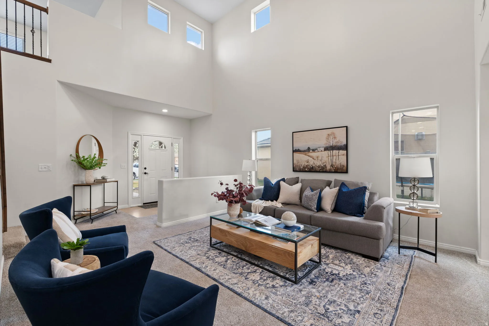 Living room featuring light colored carpet and a high ceiling