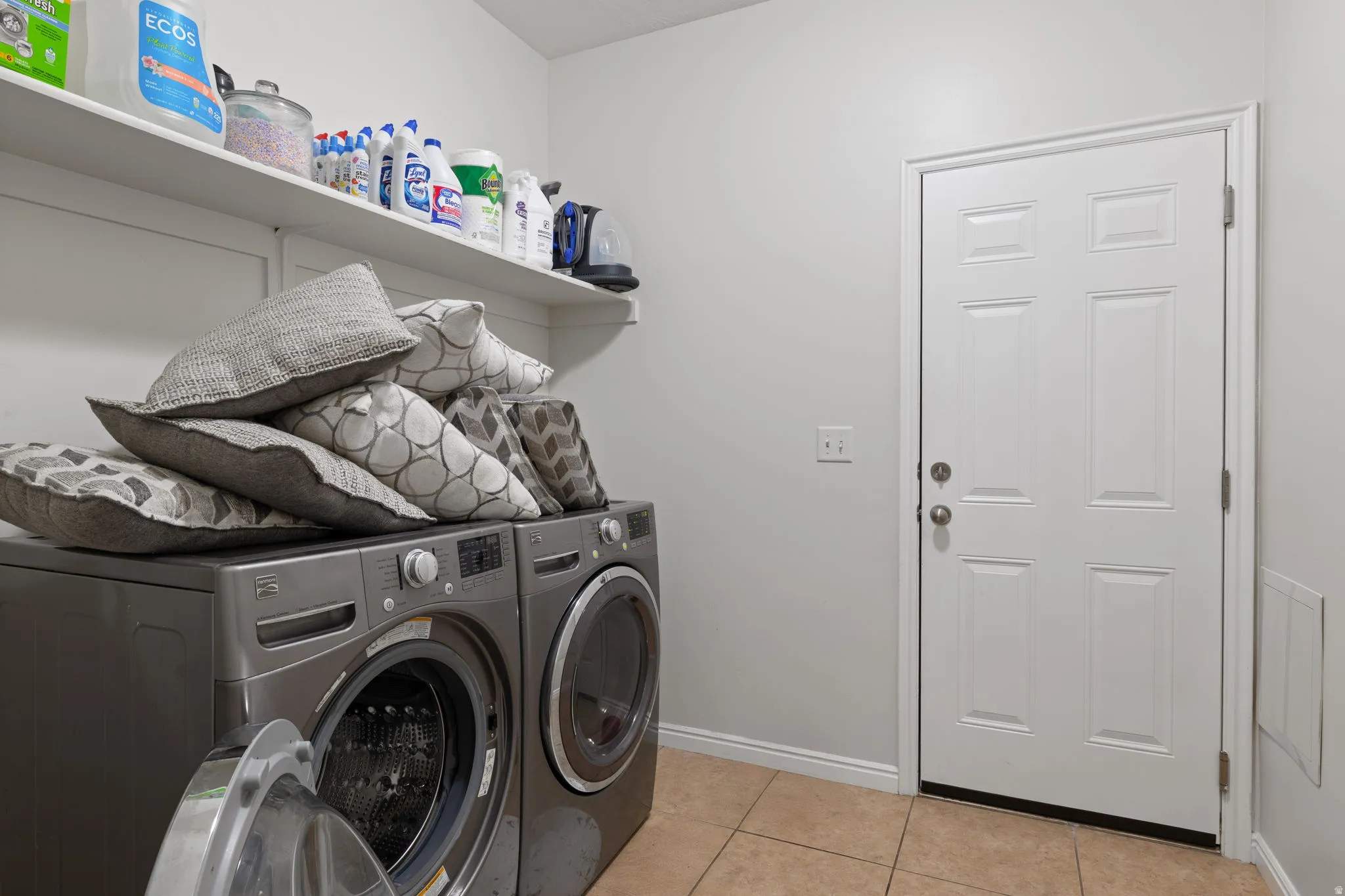 Laundry room featuring light tile patterned flooring and washing machine and clothes dryer