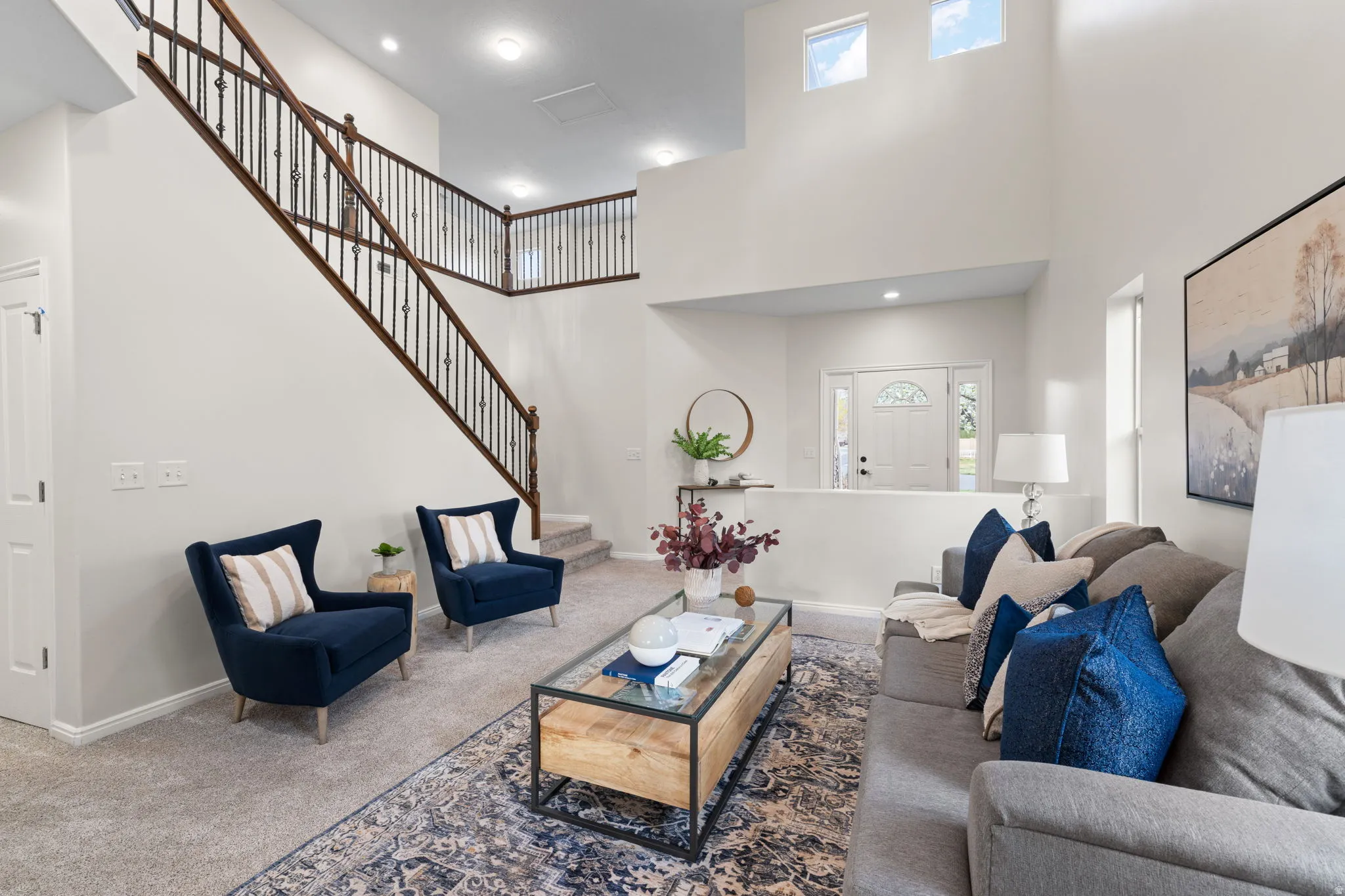 Carpeted living area with a high ceiling and recessed lighting