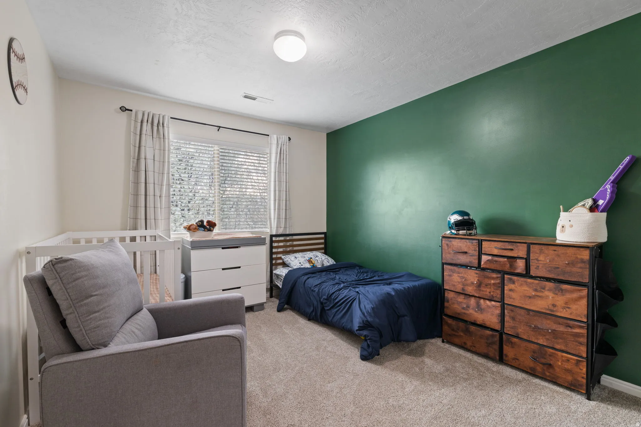 Bedroom featuring carpet flooring, a textured ceiling, and a crib