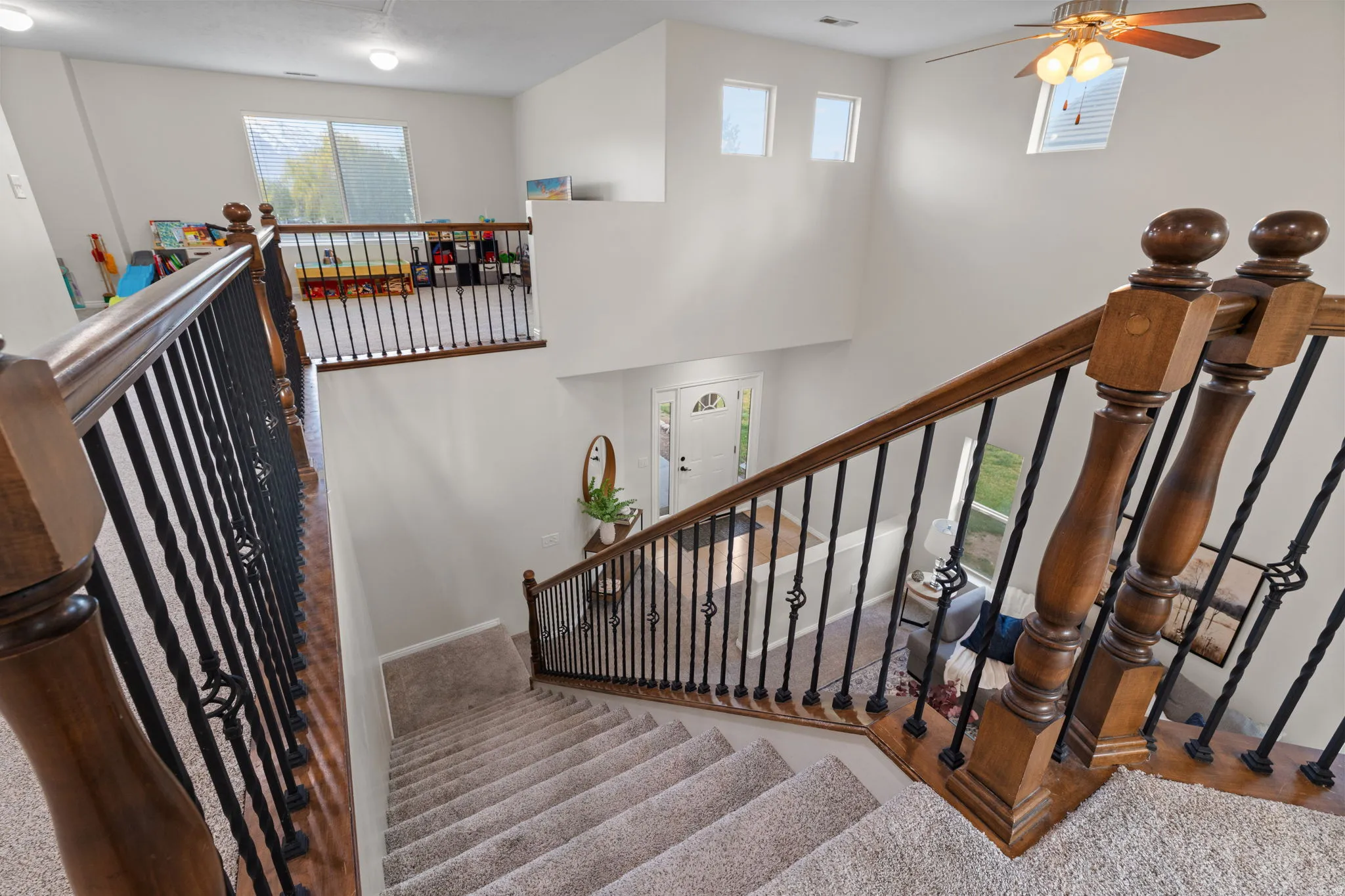 Stairway featuring healthy amount of natural light, a high ceiling, and ceiling fan